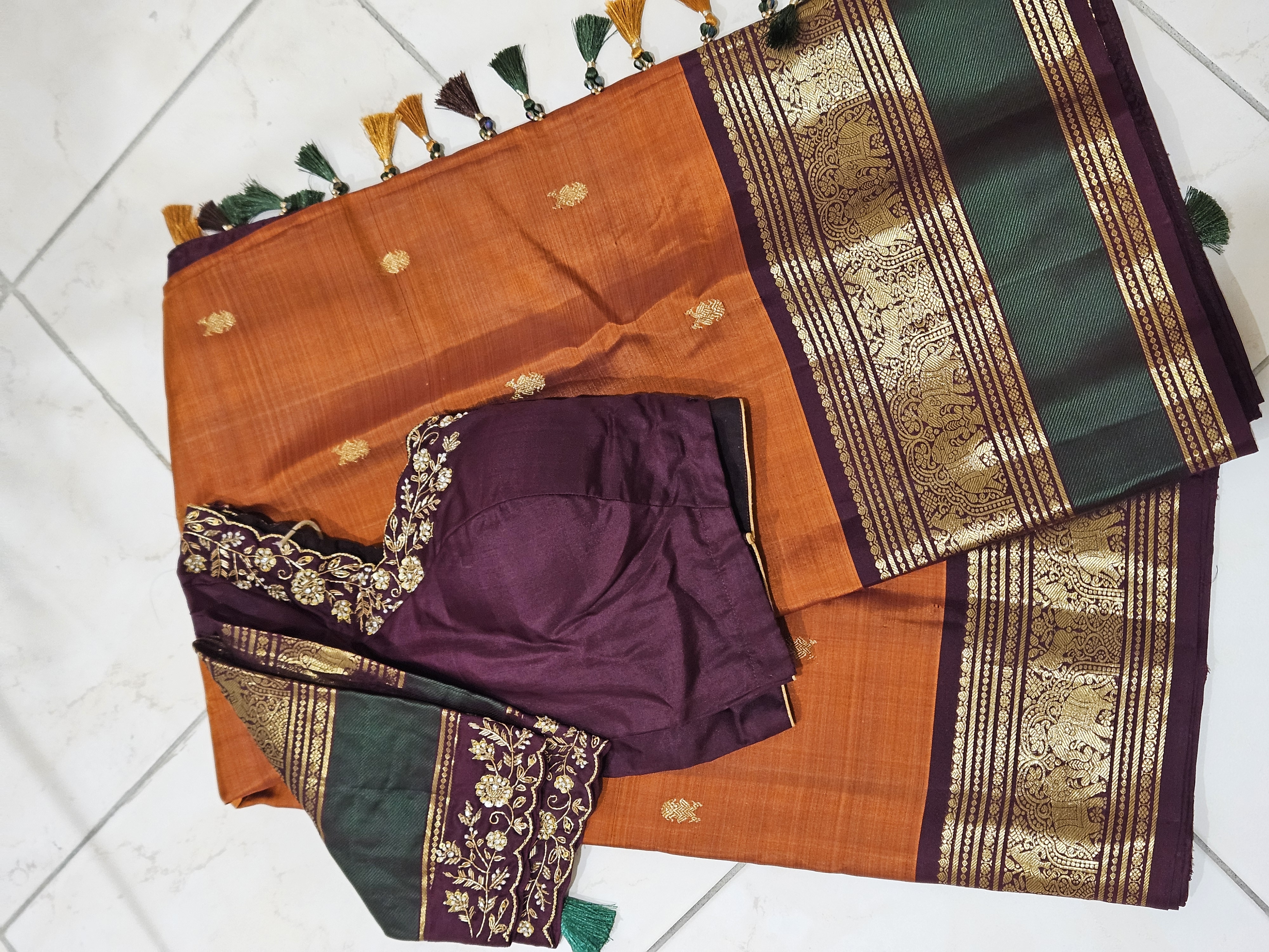 Rust orange and brown pure Kanchipuram silk saree with gold handwoven zari border, green pallu, and matching blouse piece