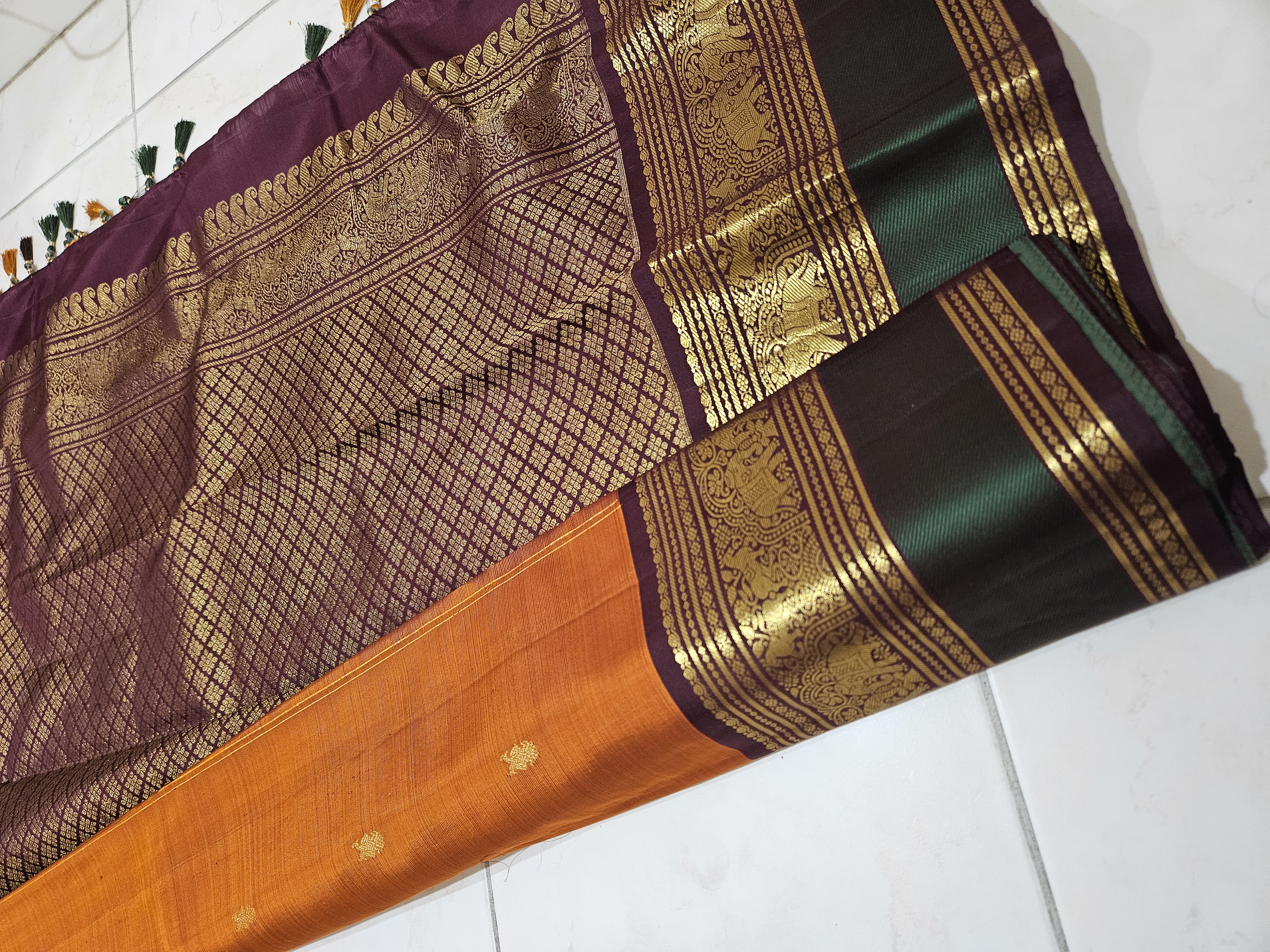 Rust orange and brown pure Kanchipuram silk saree with intricate handwoven gold zari border and traditional motifs