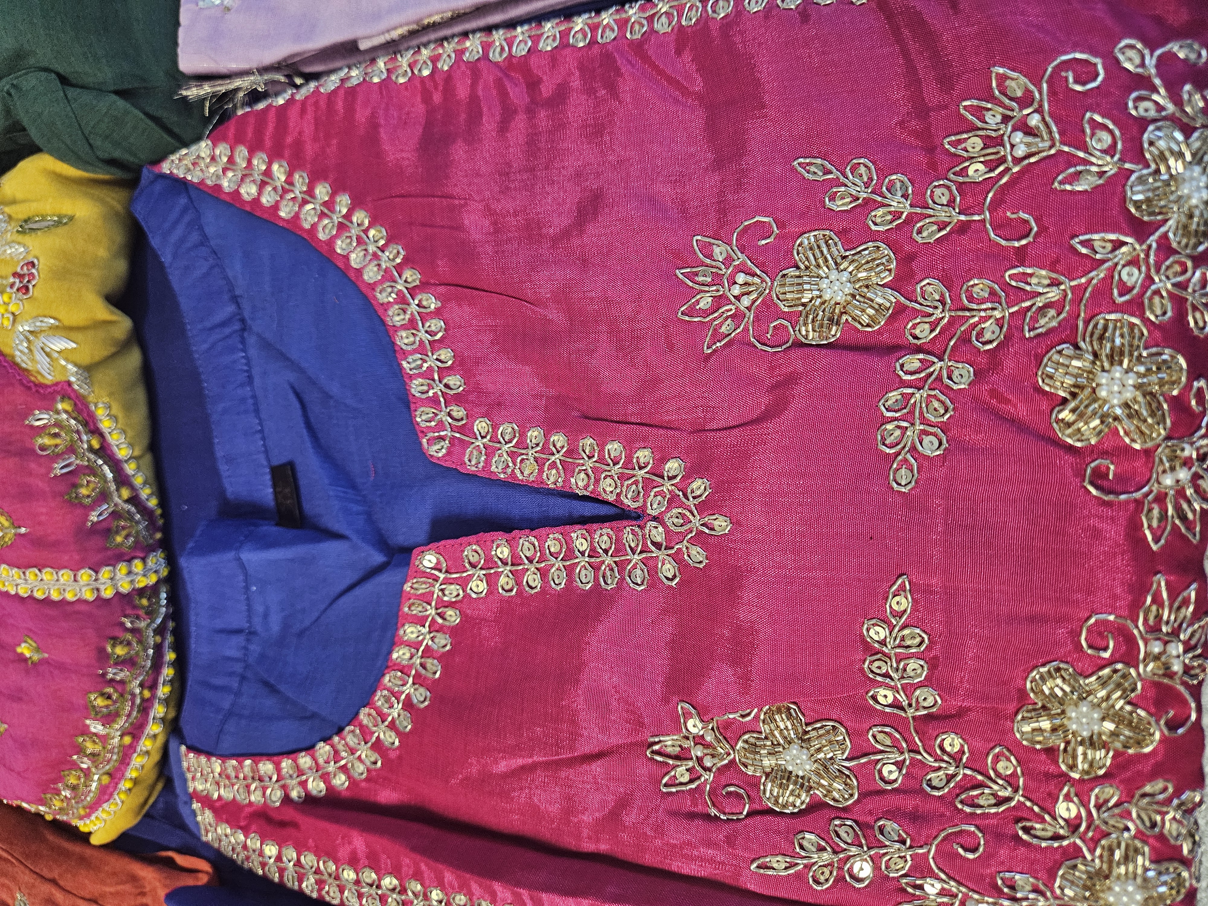 Indigo blue mul Chanderi suit set with vibrant pink yoke, gold coin accents, and intricate floral embroidery detailing.