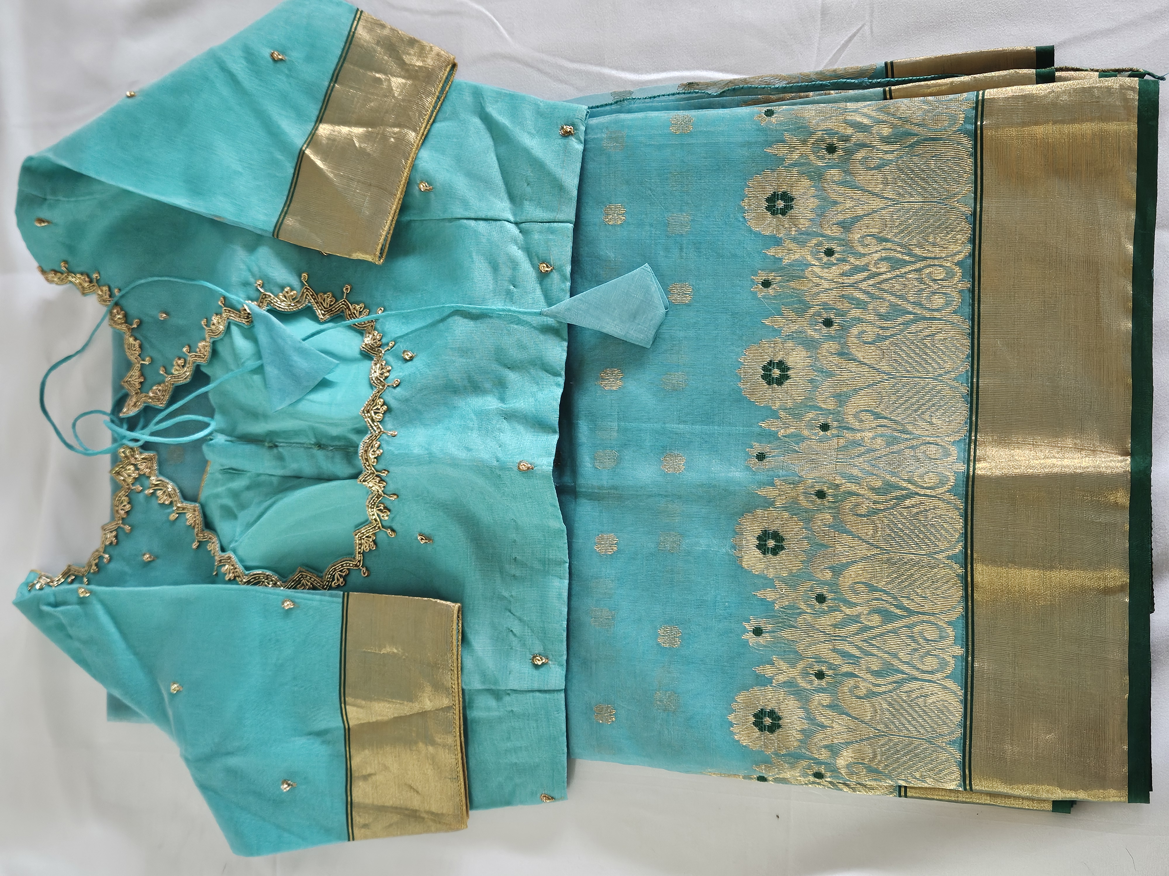 Handwoven pure Chanderi Katan silk saree in aqua blue with golden zari borders, multicolor floral motifs, and matching blouse.