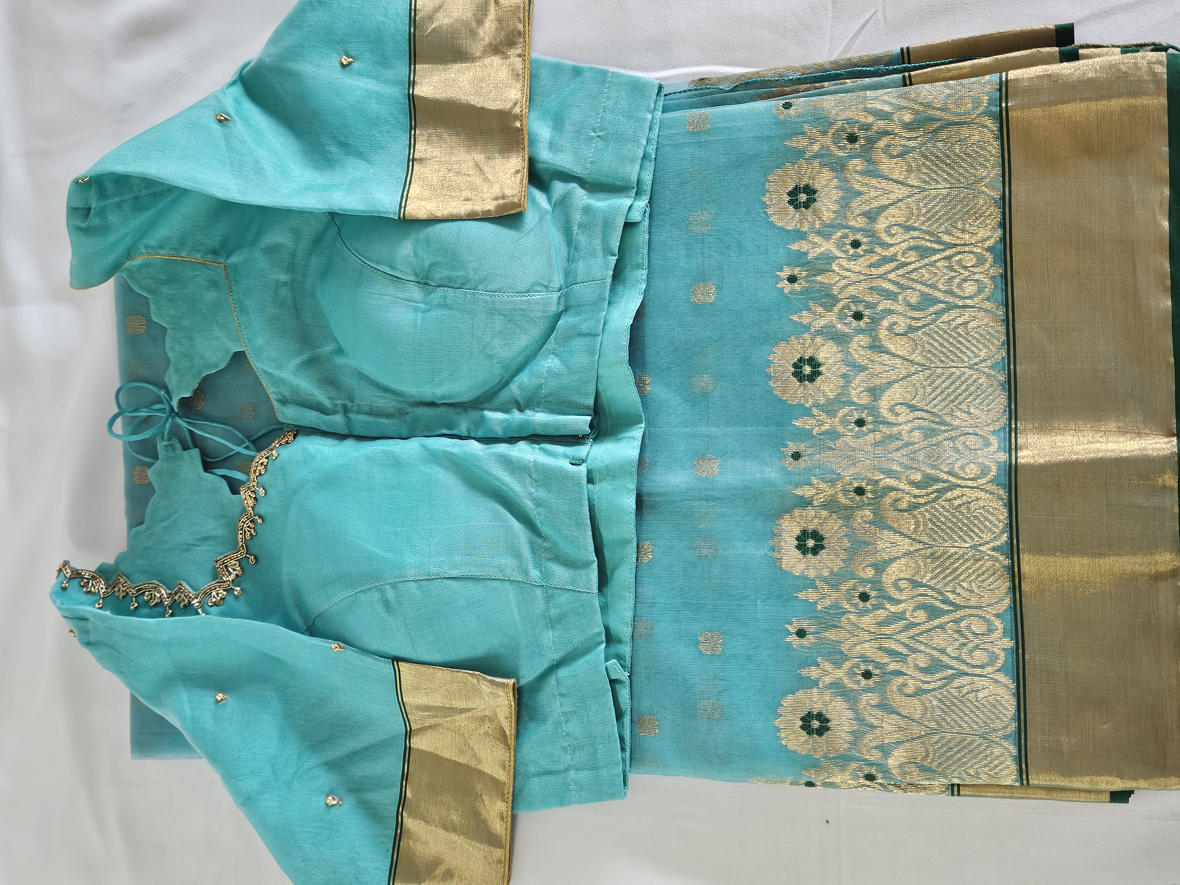 Handwoven pure Chanderi Katan silk saree in turquoise blue with golden zari borders, multicolor motifs, and matching blouse.