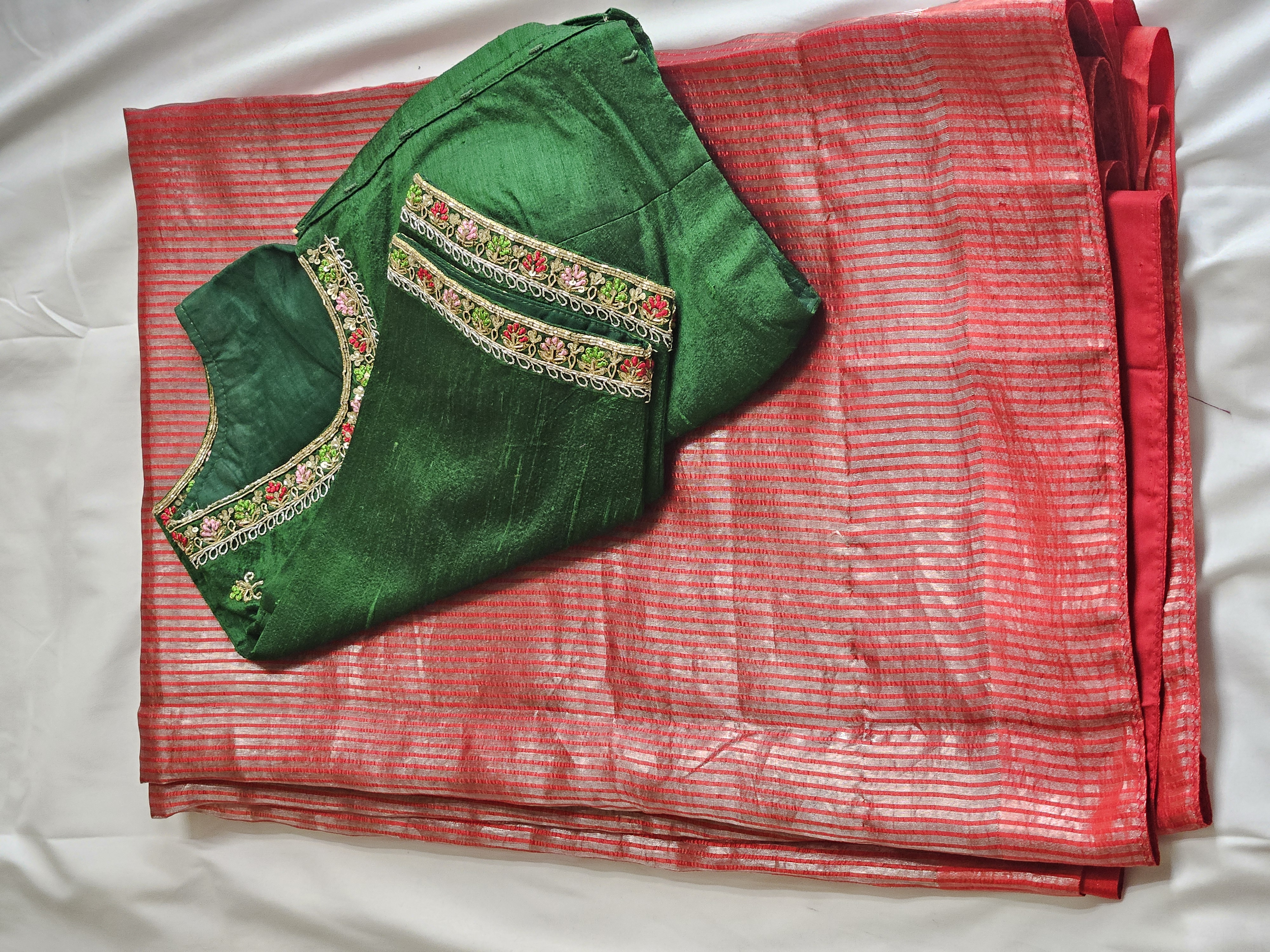 Red Banarasi tissue saree with gold stripes, paired with a green maggam embroidered blouse featuring floral detailing.
