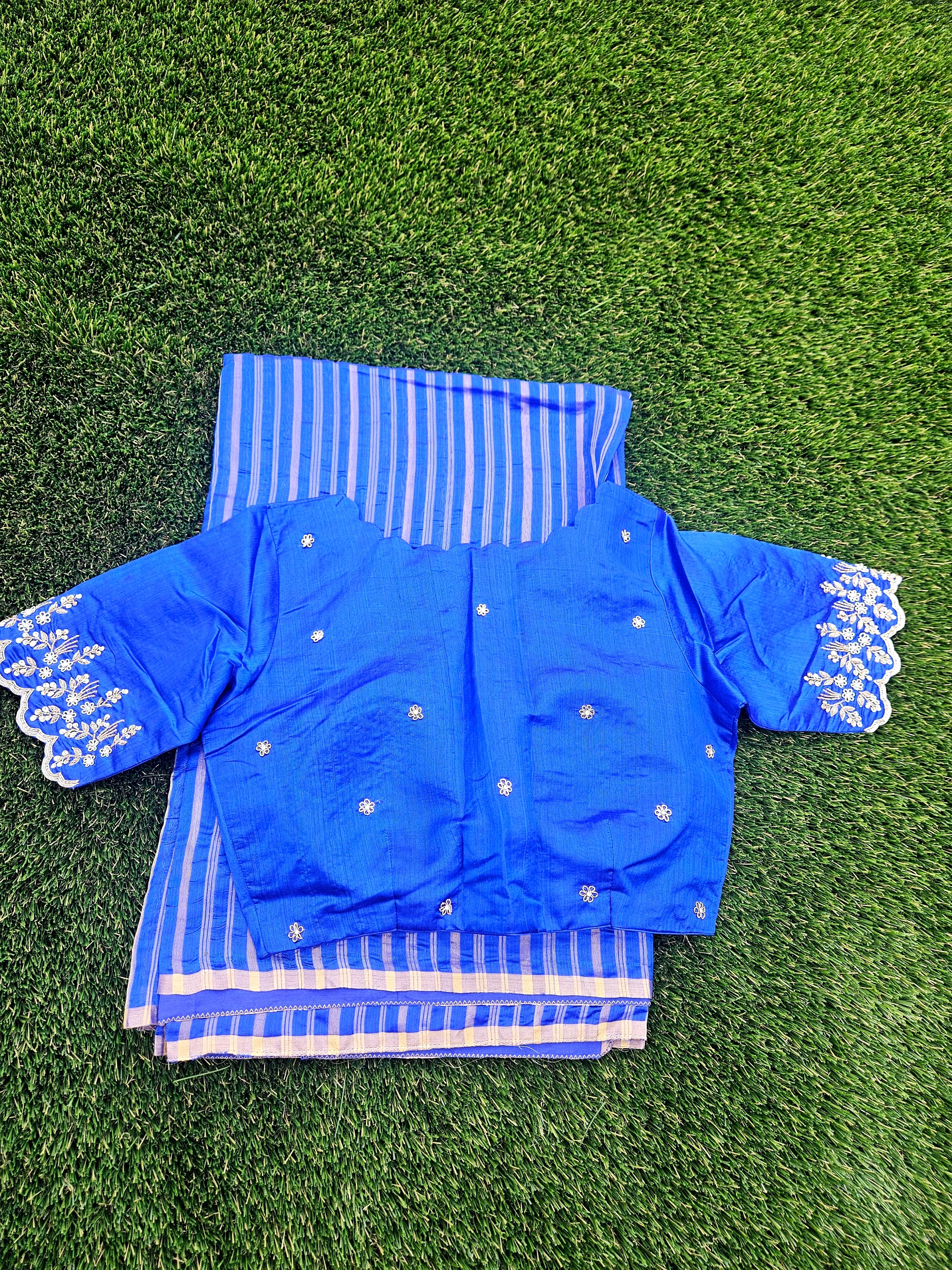 Blue Chanderi silk saree with gold zari stripes, paired with an embroidered blue blouse featuring floral motifs on sleeves