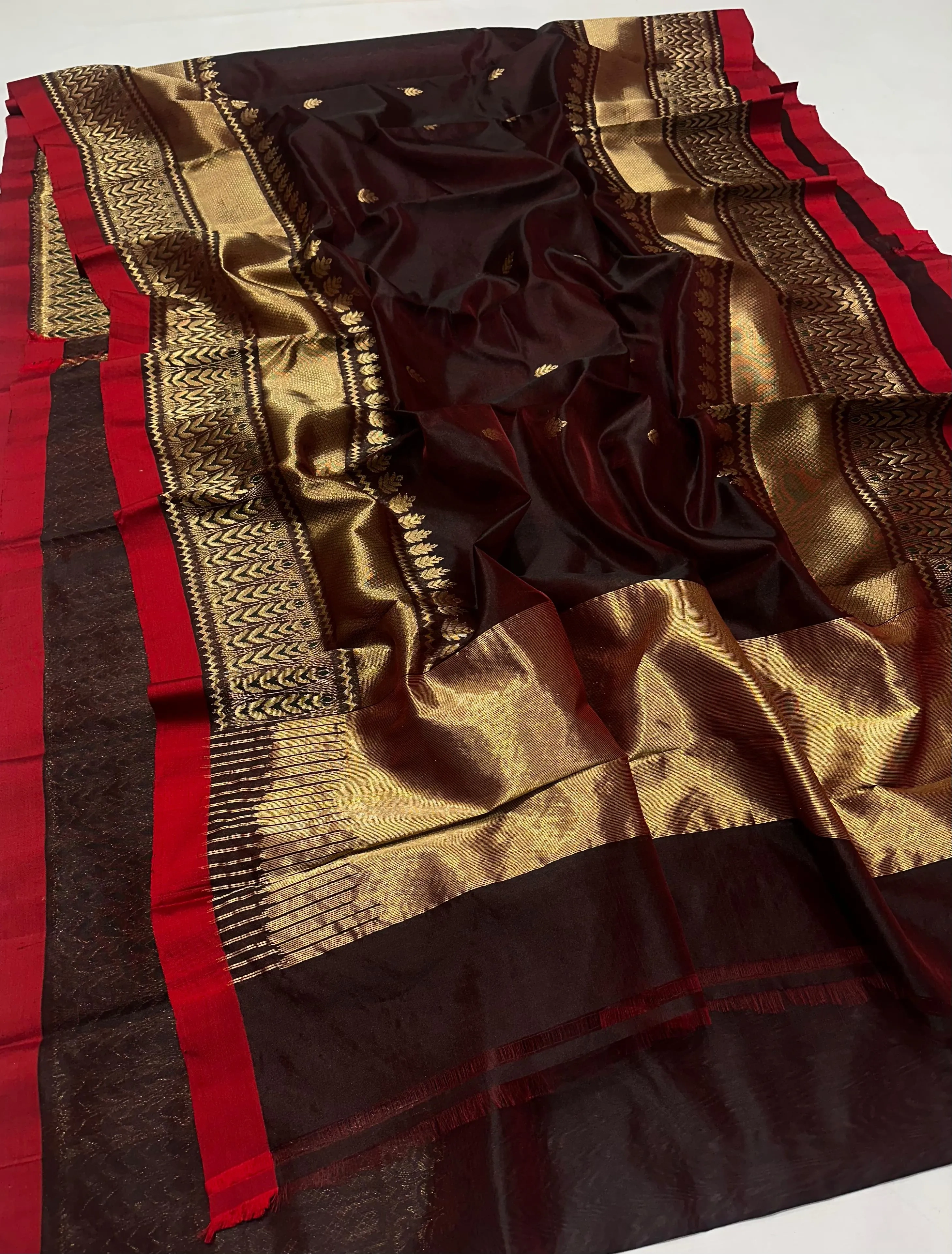 Handwoven pure Chanderi silk saree featuring rich maroon and gold tones, golden zari work, and a vibrant red border.