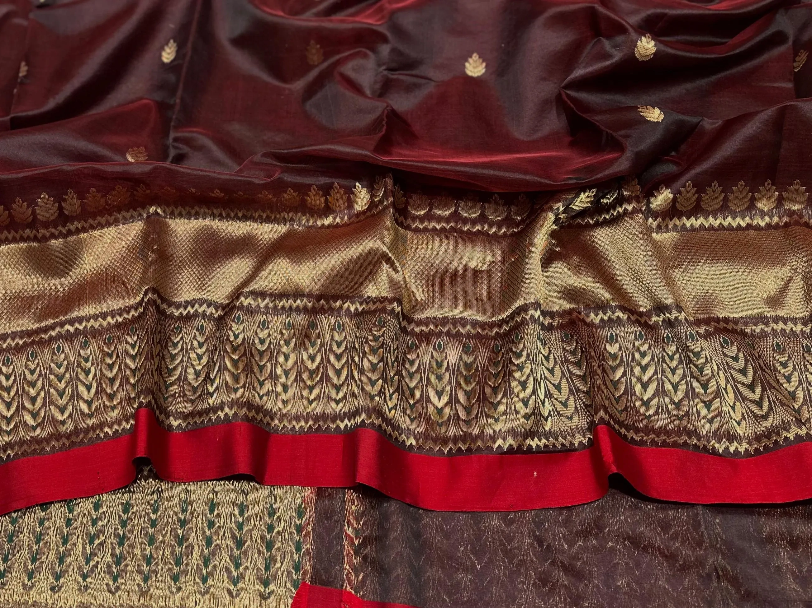 Handwoven pure Chanderi silk saree in deep maroon with golden zari motifs and intricate gold border, elegant festive wear.