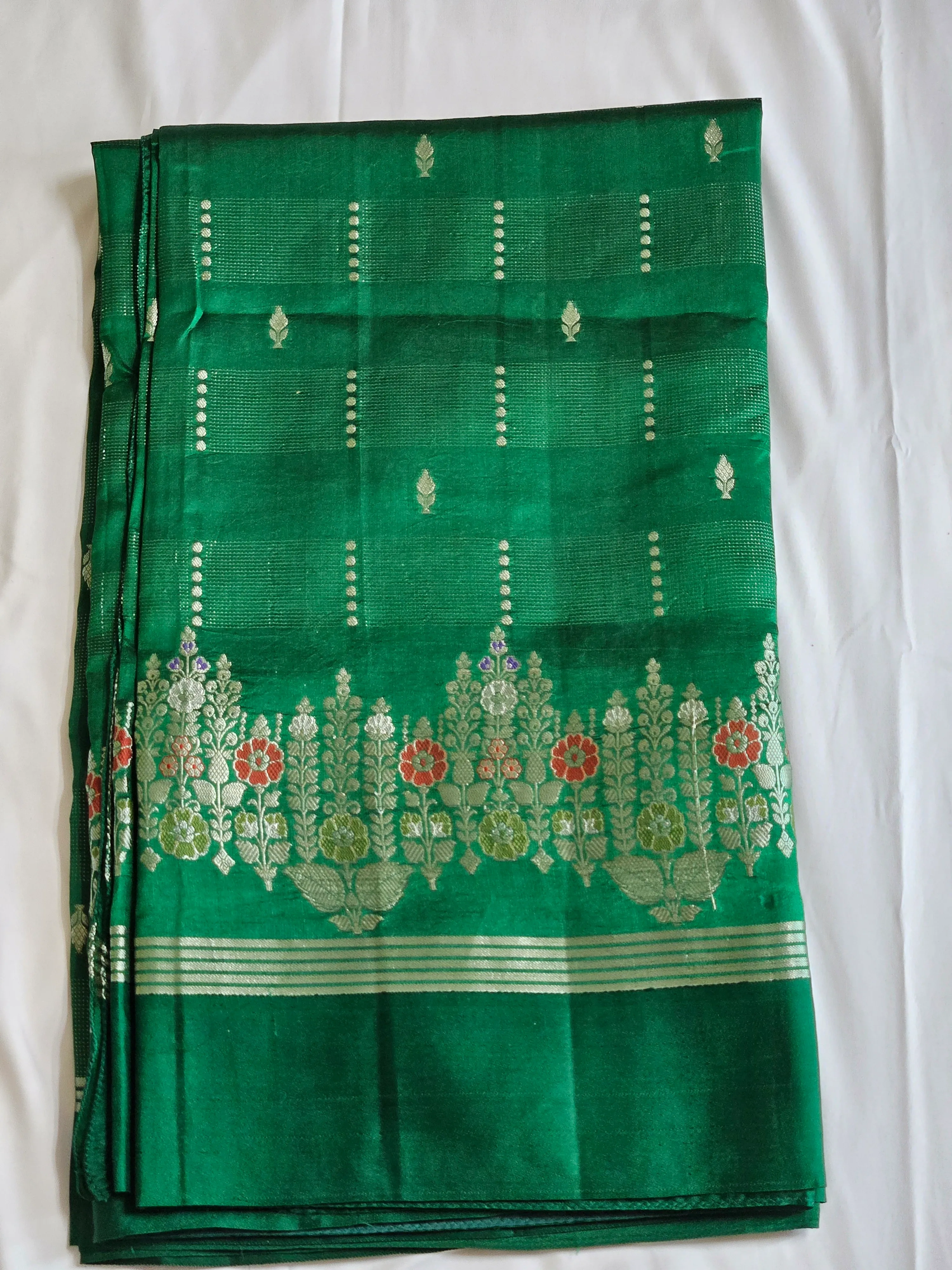 Handcrafted pure raw mango silk saree in vibrant green with silver zari floral border, ideal for weddings and festive occasions