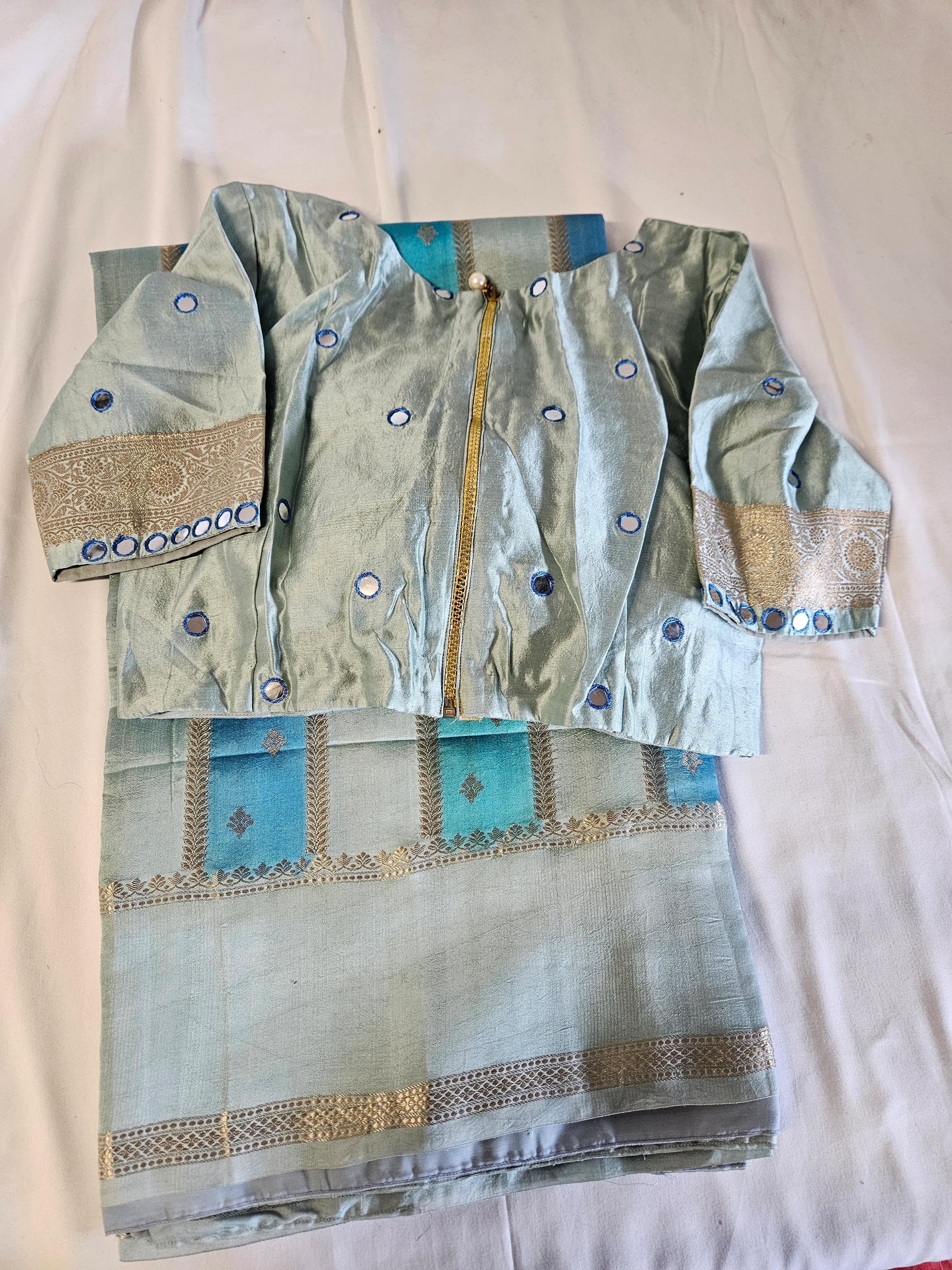 Golden yellow handwoven pure raw mango silk saree with intricate zari work, paired with matching blouse piece on display