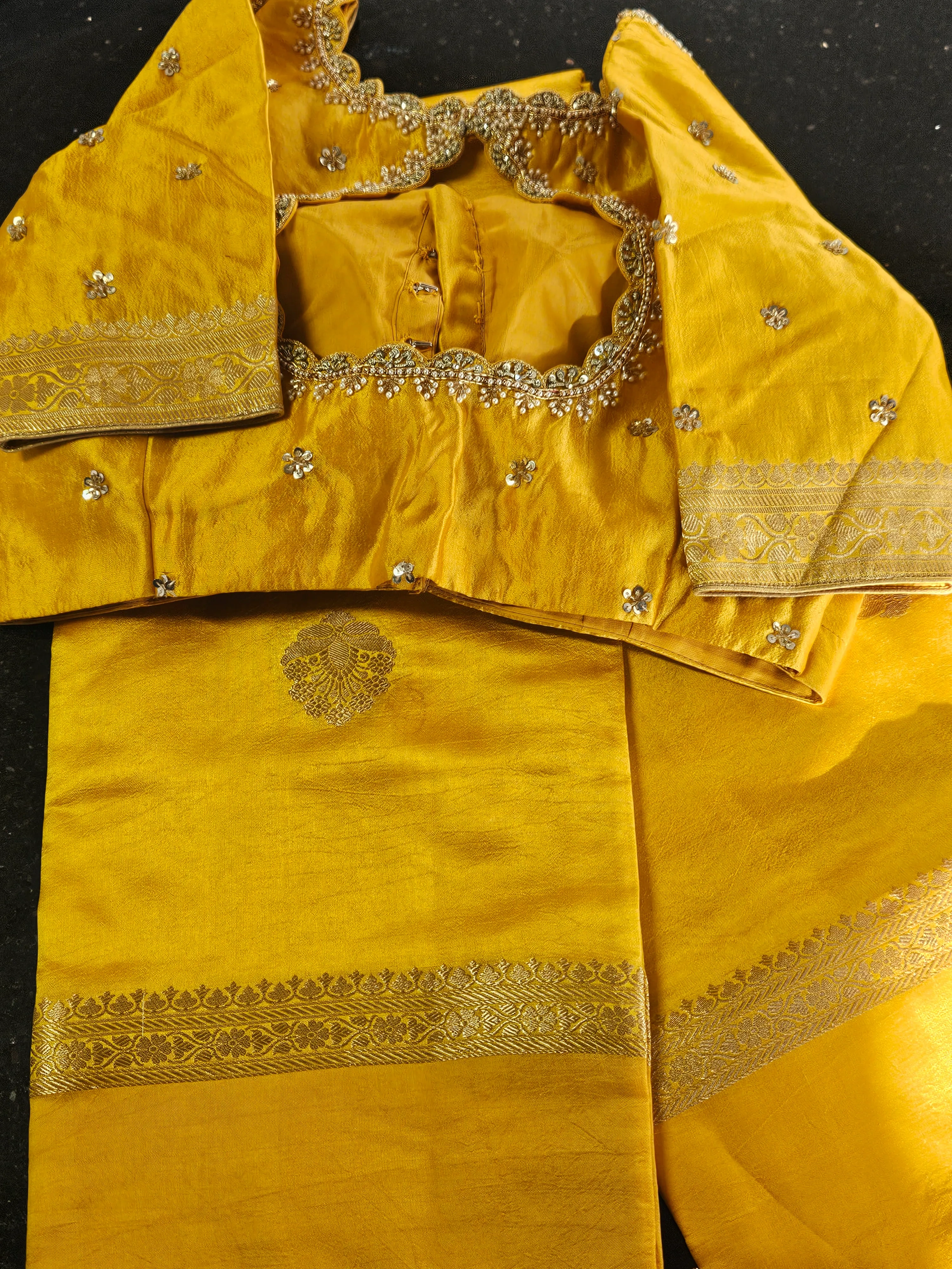 Pure raw mango silk saree in vibrant yellow with intricate gold zari border and matching embellished blouse, ideal for weddings.