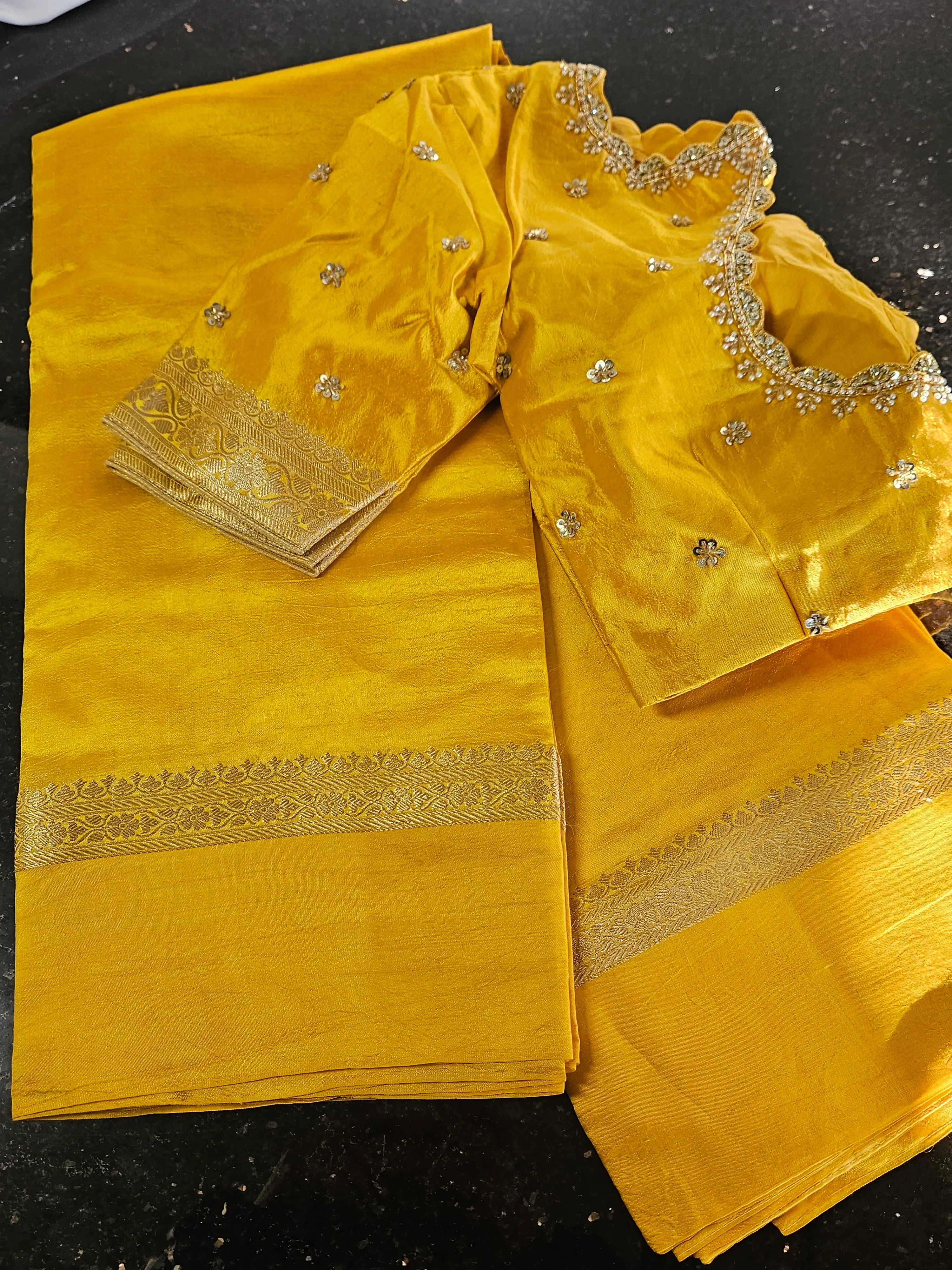Pure raw mango silk saree in vibrant yellow with intricate gold zari border and matching embellished blouse, ideal for weddings.