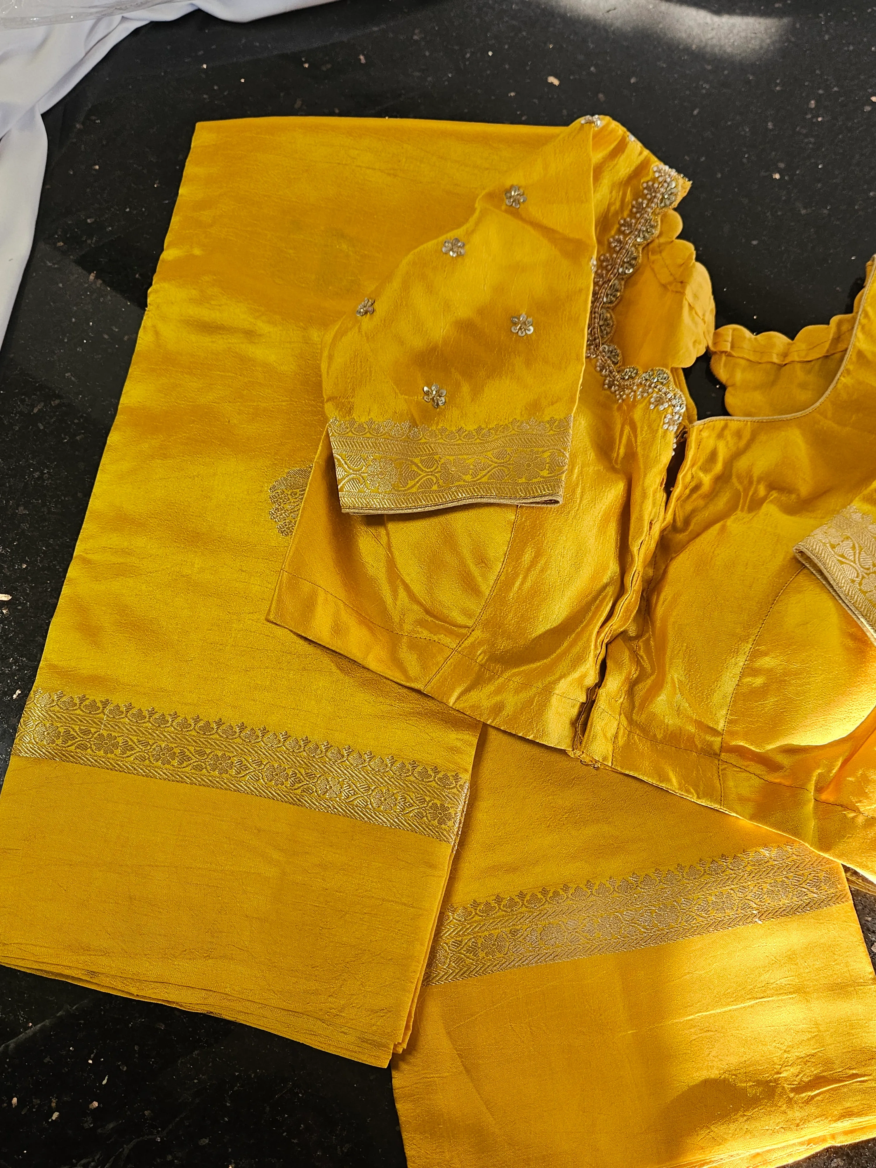 Pure raw mango silk saree in vibrant yellow with intricate gold zari border, paired with matching embellished blouse