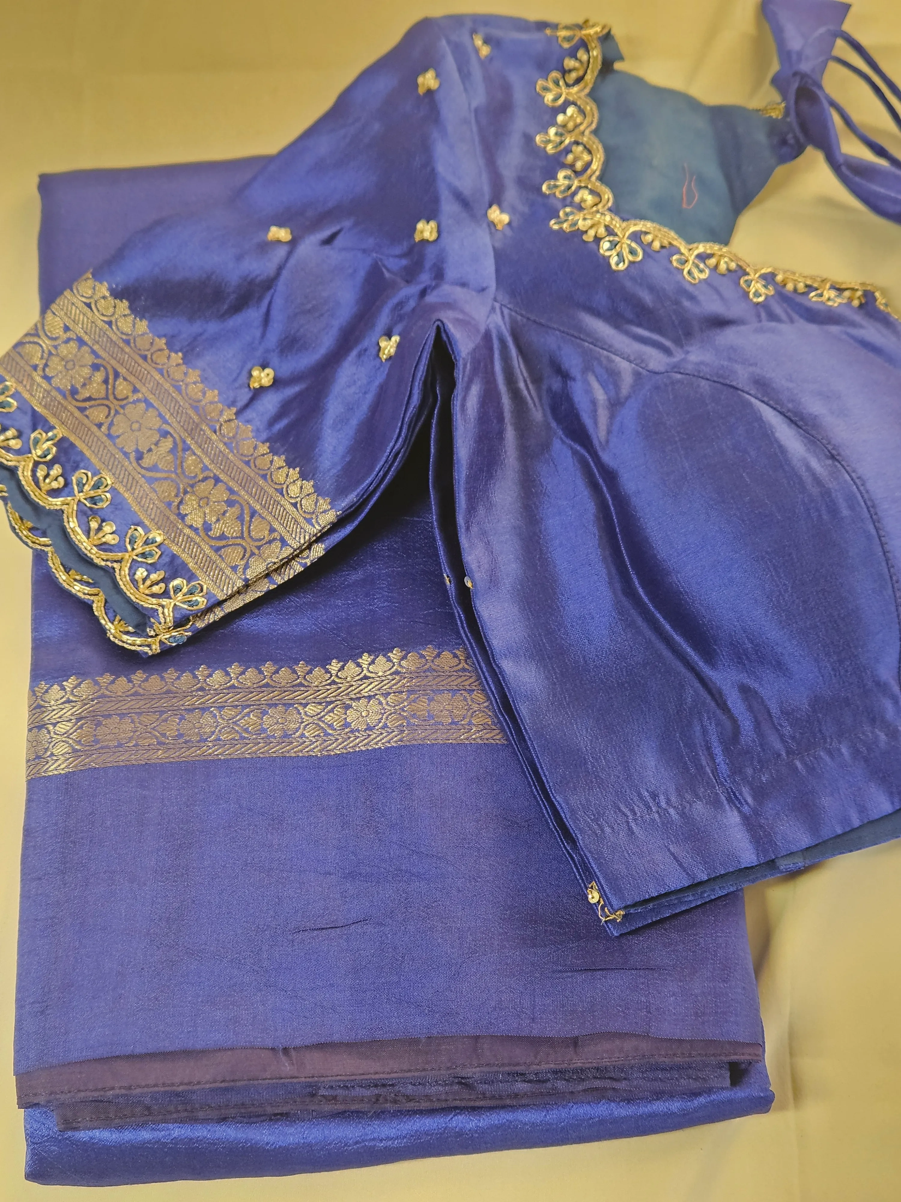 Handwoven pure raw mango silk saree in golden yellow with intricate gold zari border, paired with a royal blue blouse featuring gold embroidery, ideal for weddings and festive occasions.