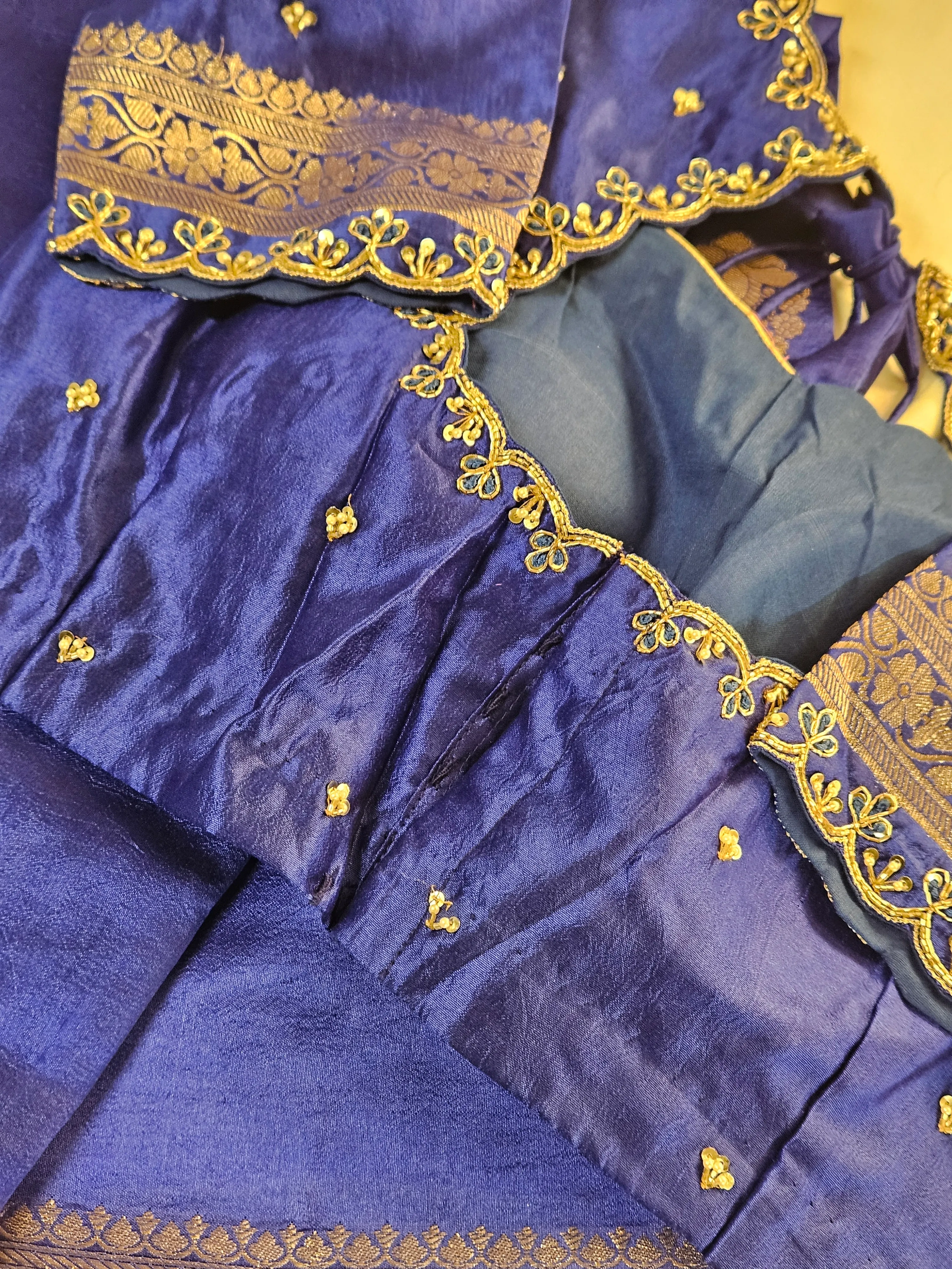 Handwoven pure raw silk saree in royal blue with gold zari border and intricate floral embroidery, ideal for weddings.