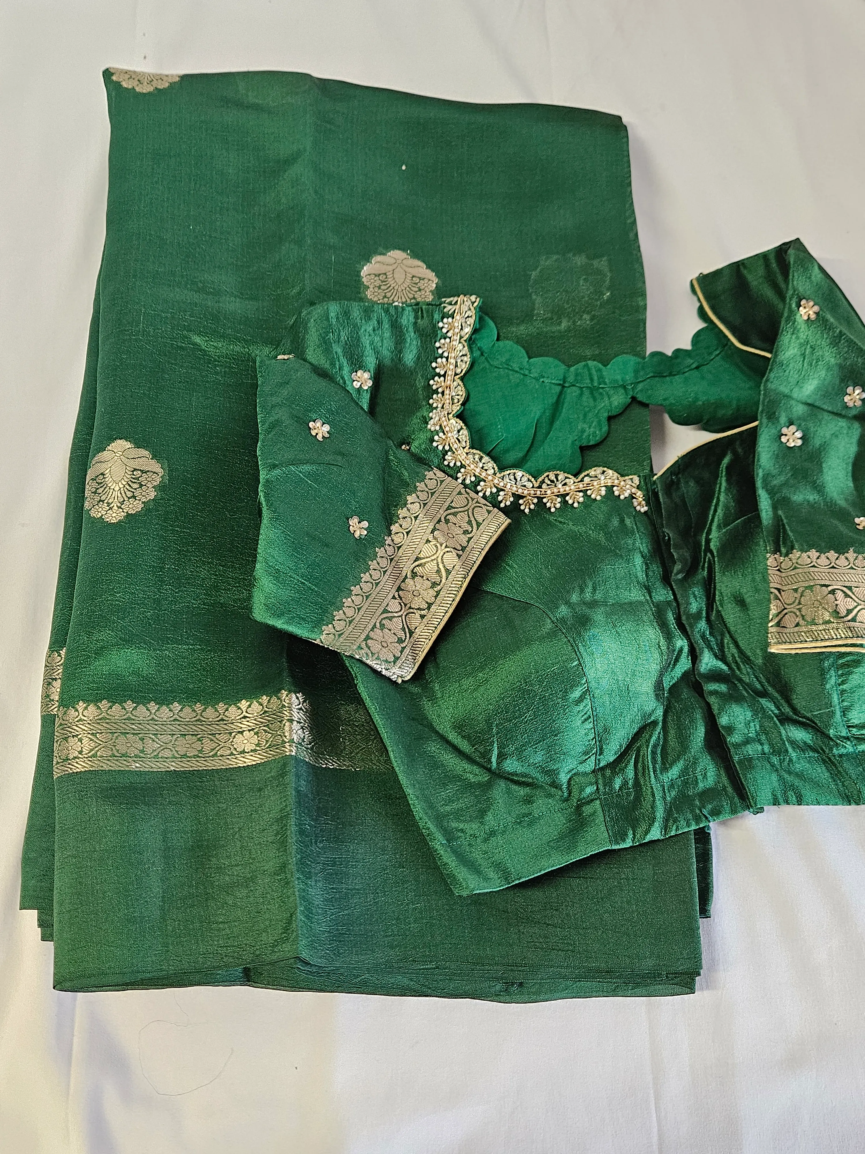 Emerald green pure raw mango silk saree with gold zari motifs and matching embroidered blouse, ideal for weddings.