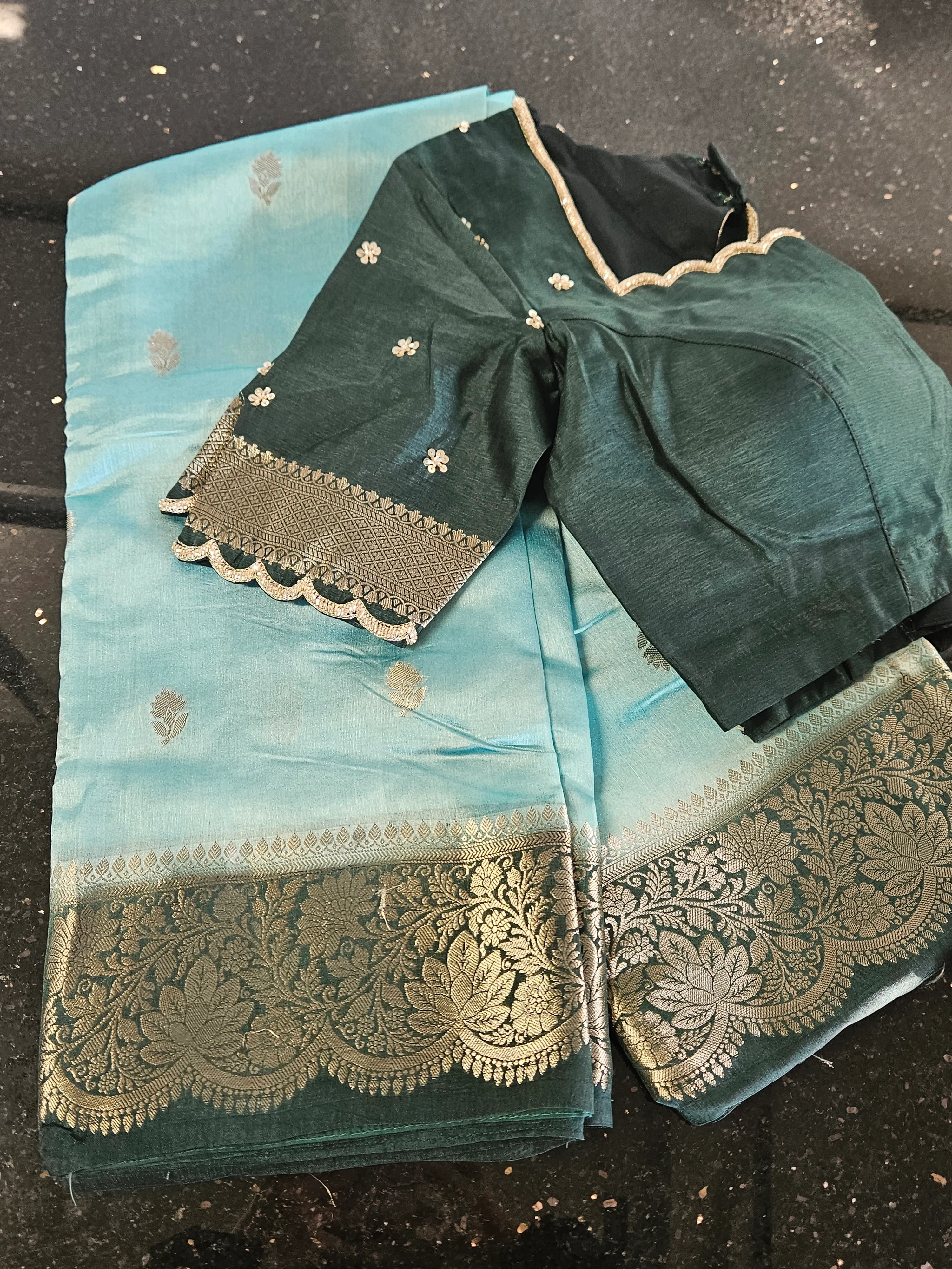 Handwoven pure raw mango silk saree in vibrant teal blue with gold zari floral border, paired with matching blouse.