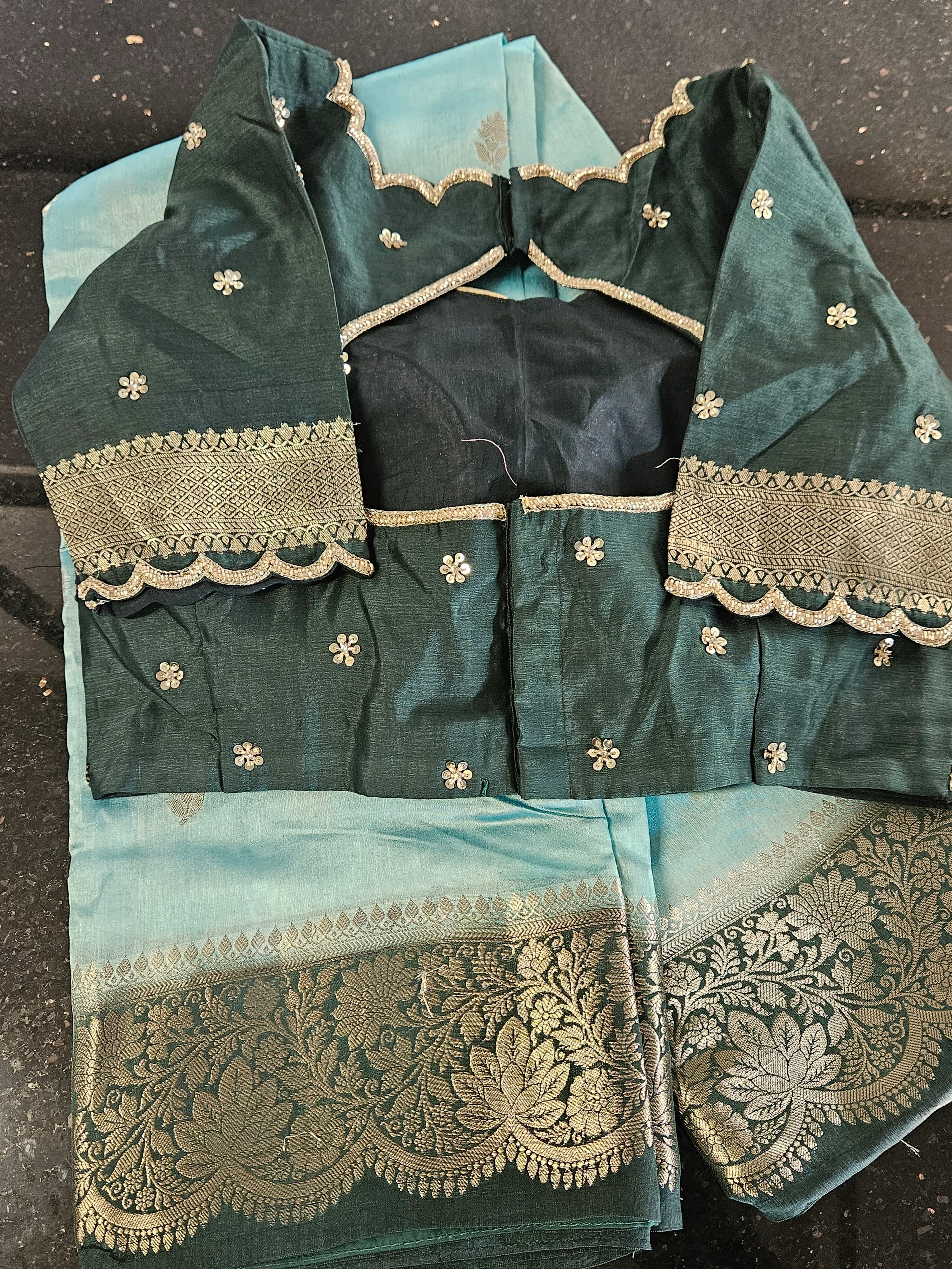 Handwoven pure raw mango silk saree in teal and aqua with gold zari floral border, paired with embroidered blouse.
