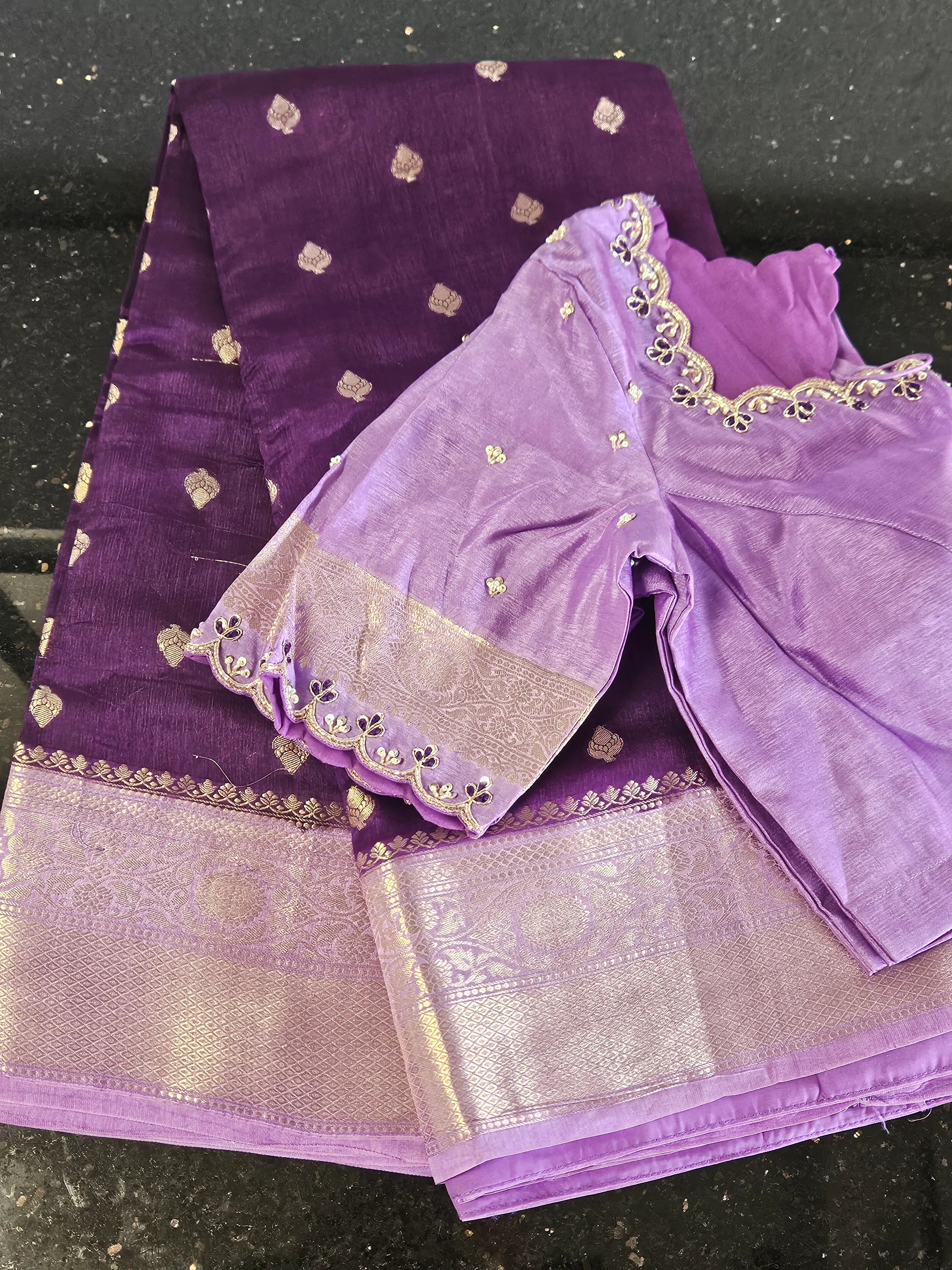 Handwoven purple silk saree with gold zari motifs and border, paired with a matching blouse featuring delicate embroidery.