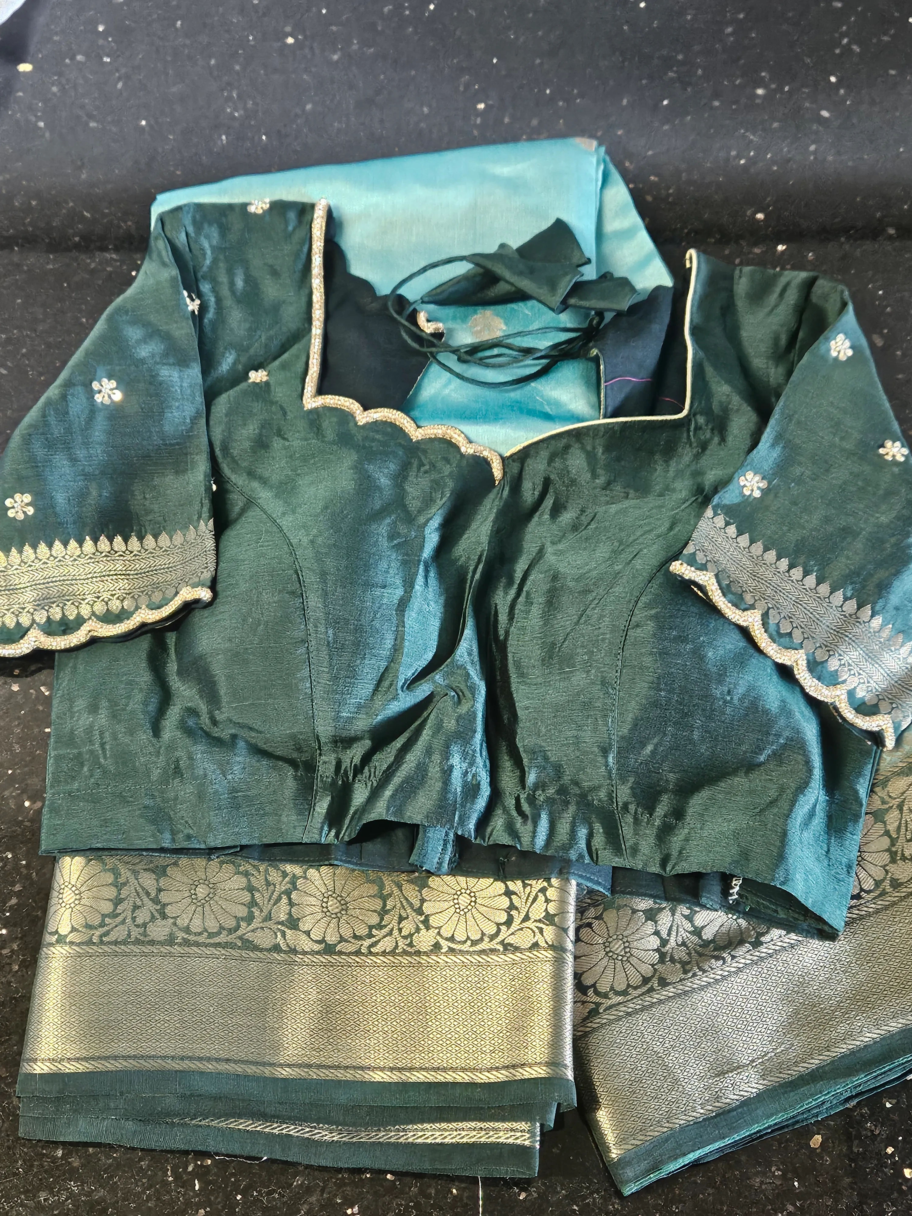 Luxury pure raw mango silk saree in deep teal with gold zari border, paired with matching embroidered blouse and pallu.