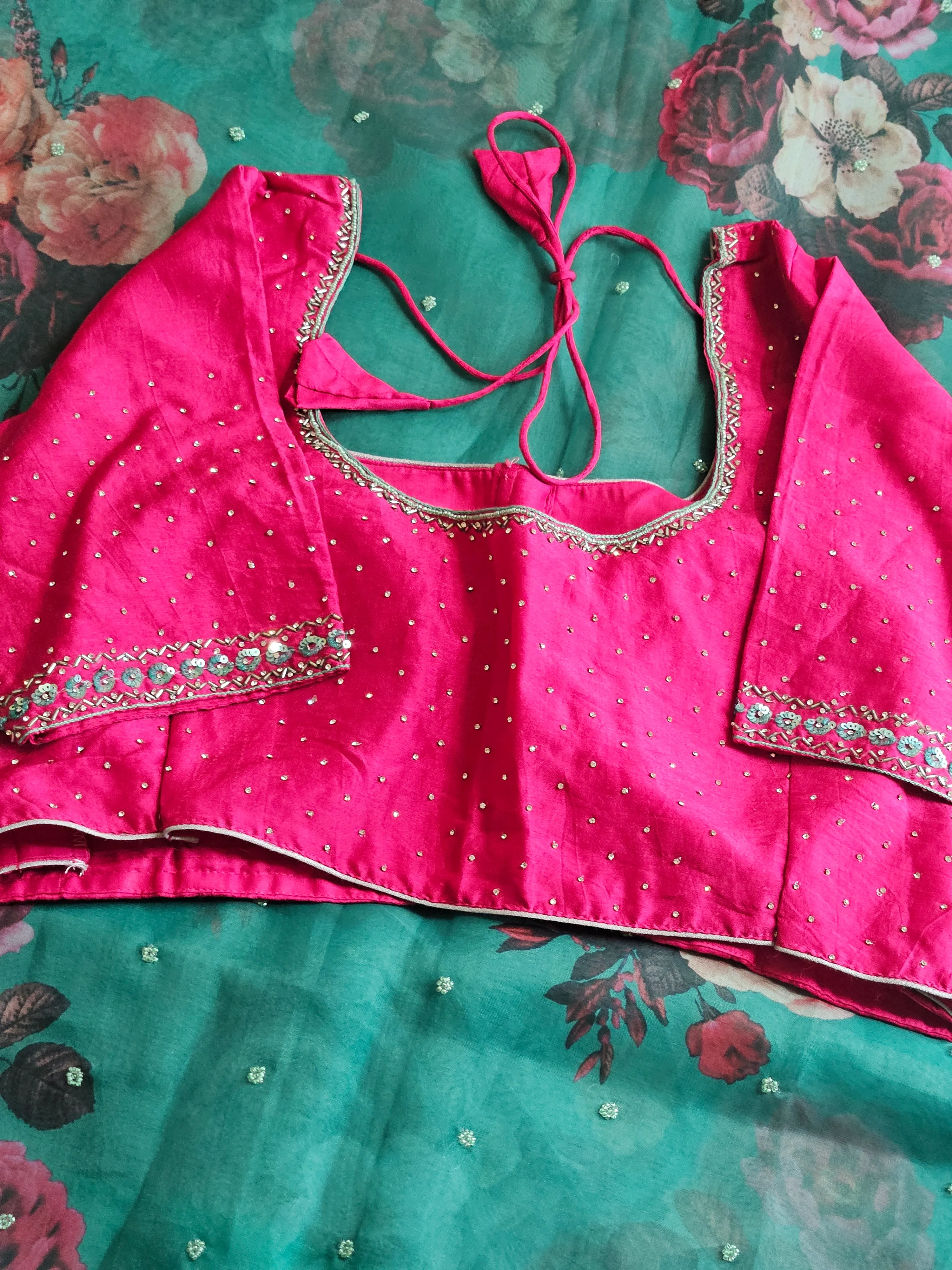 Ivory pure organza saree with vibrant multicolor floral embroidery, paired with a bright pink embellished blouse, ideal for weddings.