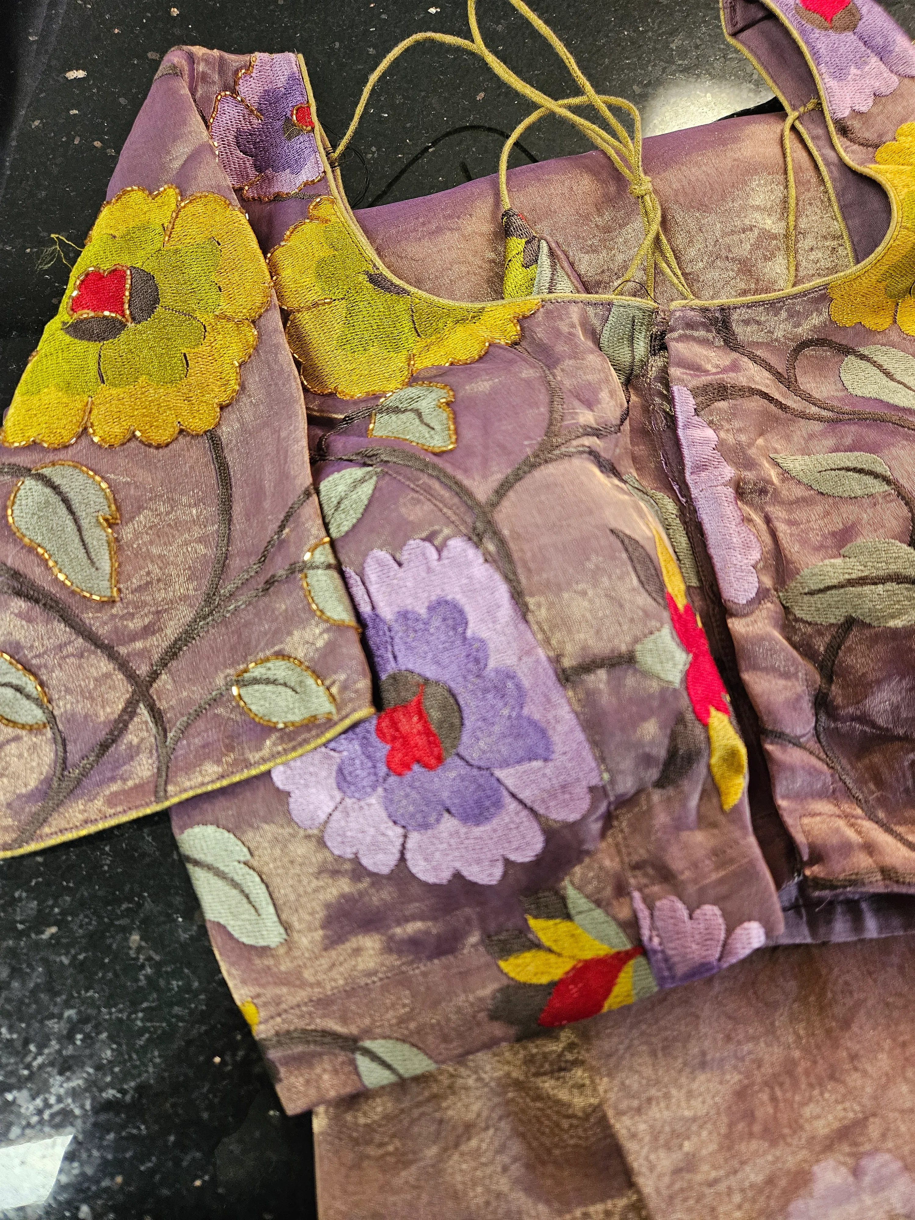 Handwoven pure Banarasi tissue saree with golden zari, luxe shimmer, and vibrant floral embroidery in purple and yellow.