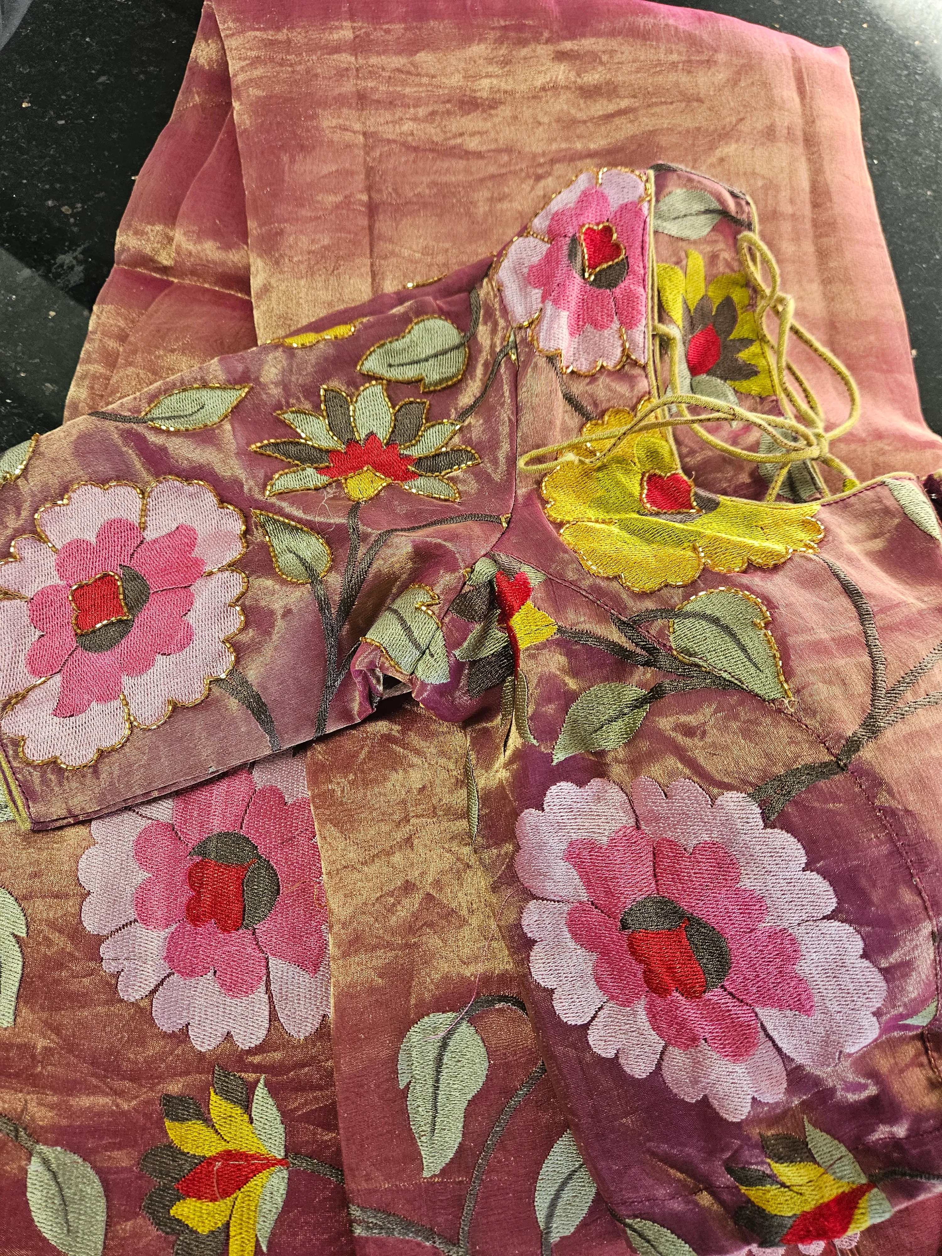 Handwoven golden Banarasi tissue silk saree with pink and red floral embroidery, paired with matching blouse piece