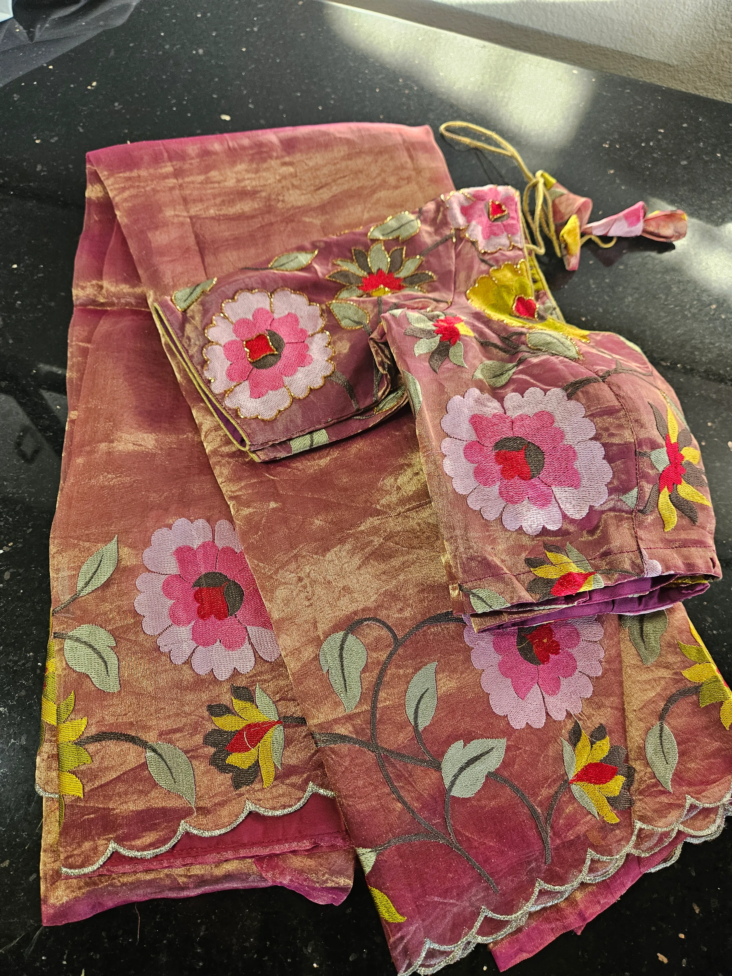 Handwoven golden Banarasi tissue silk saree with pink and red floral embroidery, scalloped border, and matching blouse.
