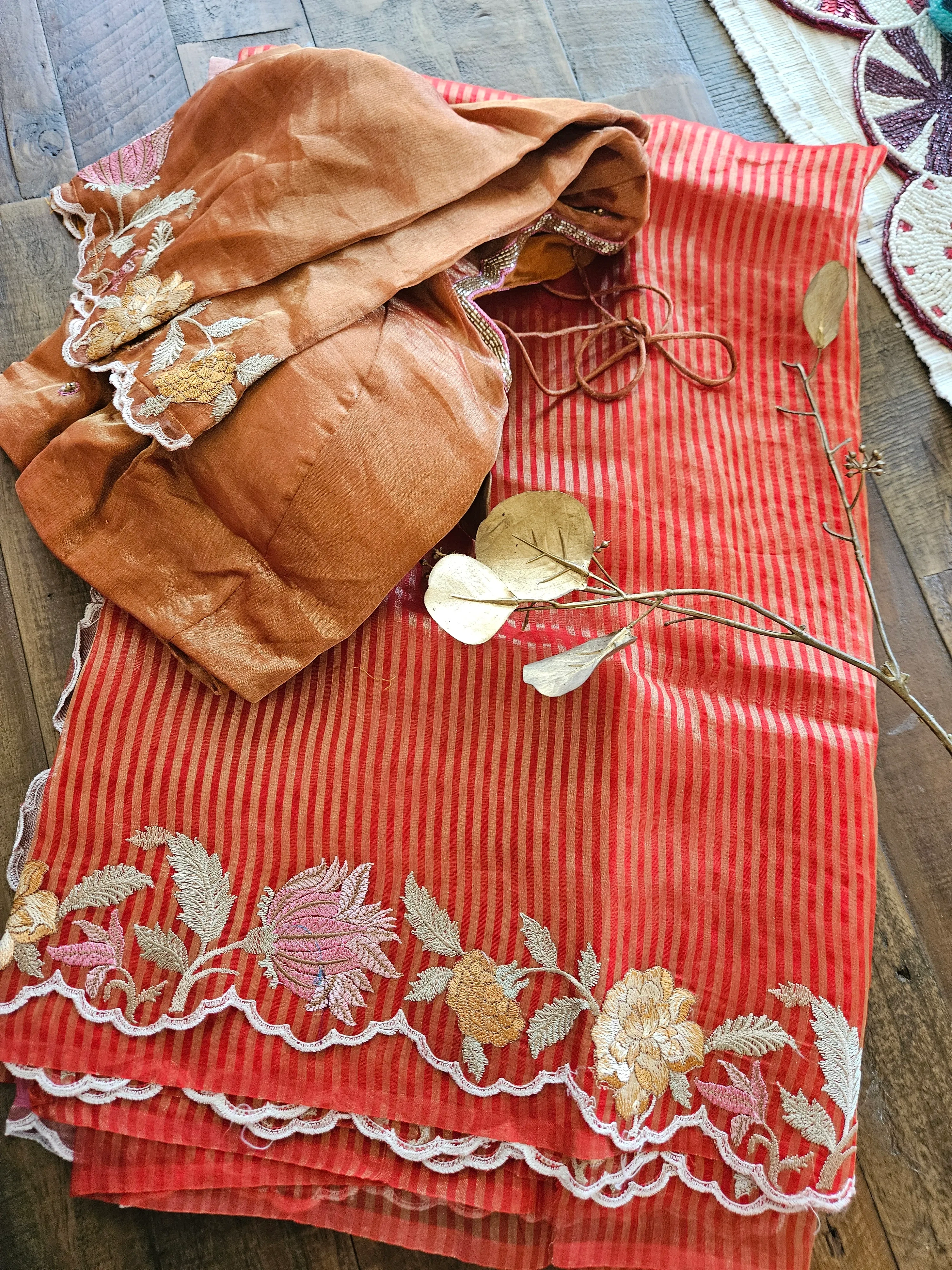 Handwoven Banarasi Kora tissue silk saree in red with gold and silver zari floral motifs and striped pattern, paired with a brown blouse.