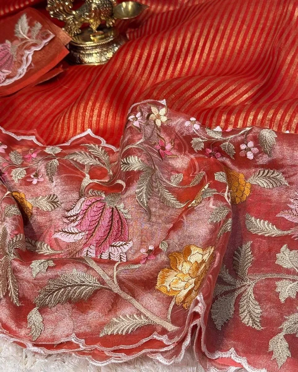 Handwoven Banarasi Kora tissue silk saree in coral red with gold and silver zari floral motifs and striped pallu detailing.