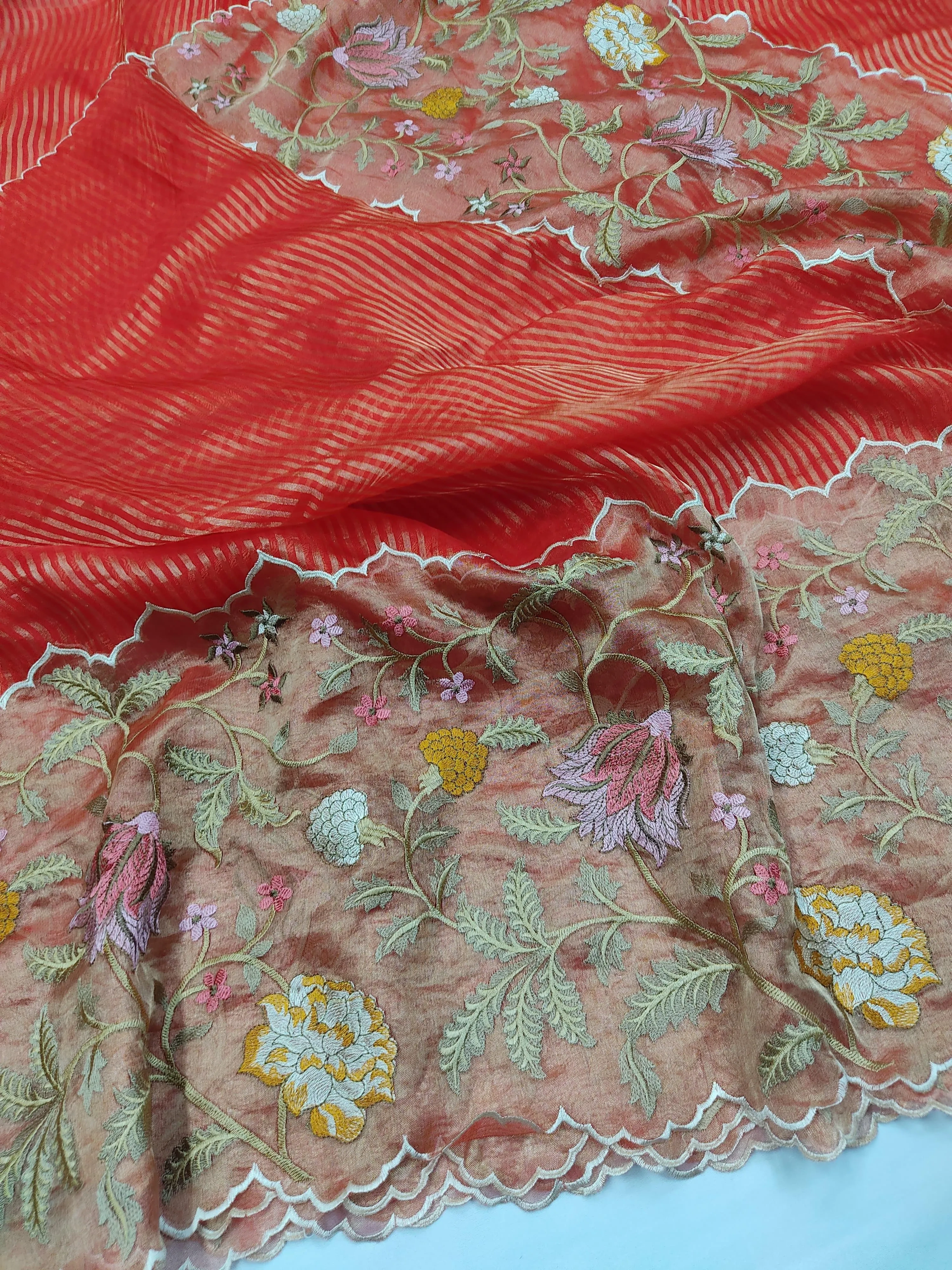 Handwoven Banarasi Kora tissue silk saree in coral red with gold and silver zari floral motifs and scalloped border