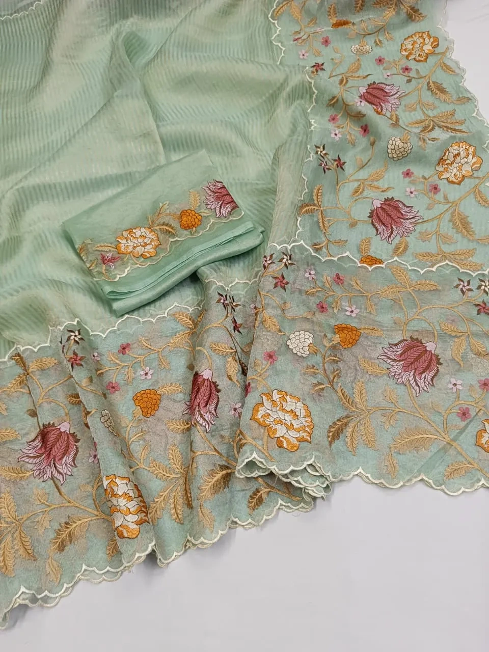 Handwoven Banarasi Kora tissue silk saree in pastel green with intricate golden Mughal zari floral motifs and scalloped border