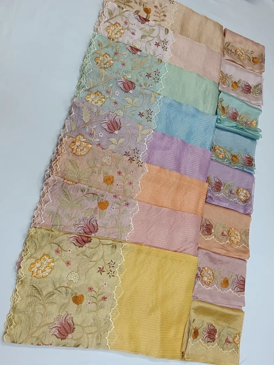 Handwoven Banarasi Kora tissue saree in gold with pastel color panels, floral zari embroidery, and scalloped borders