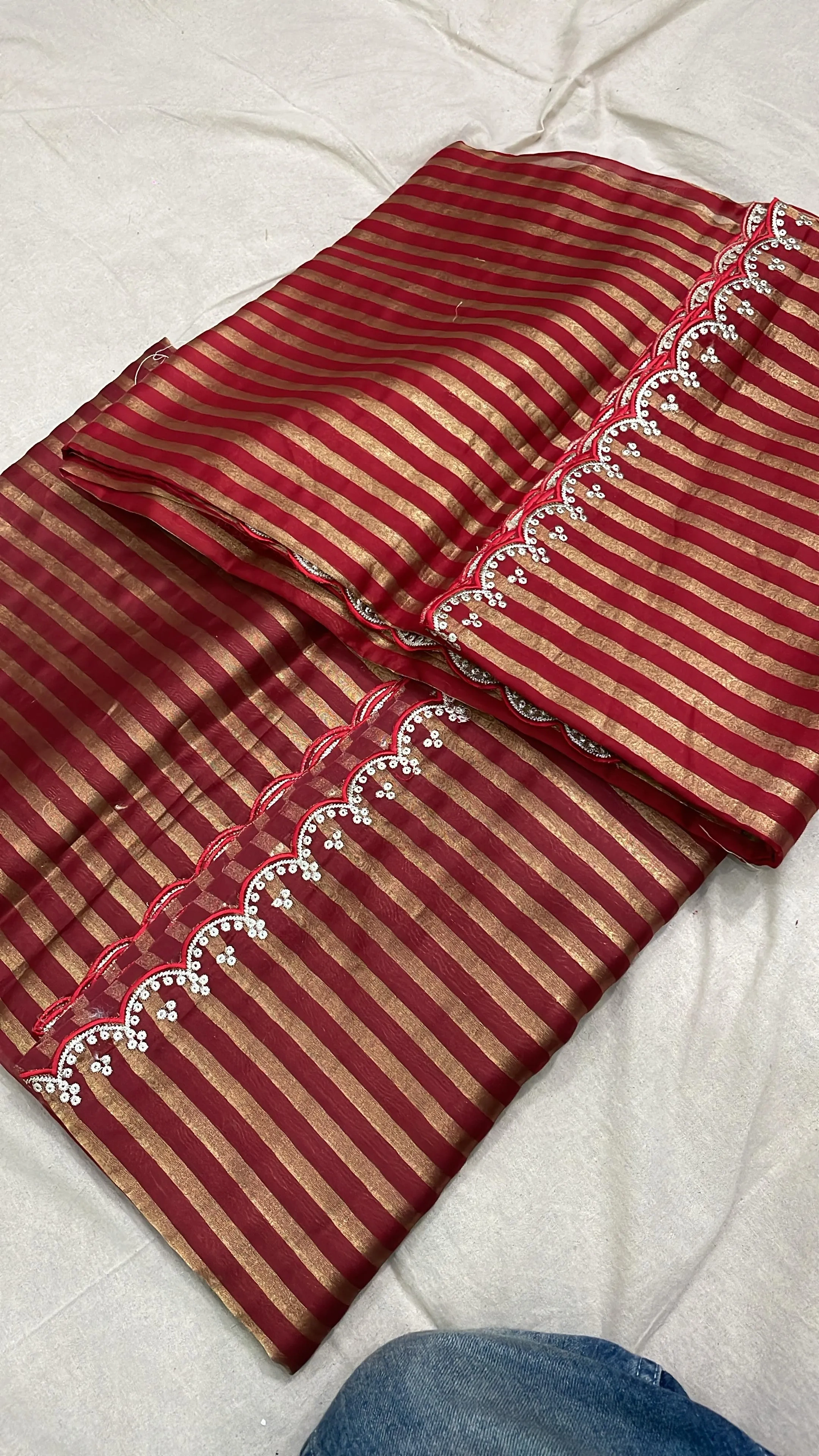 Pure Banarasi Kora silk tissue saree in deep red with golden zari stripes and intricate scalloped border, ideal for weddings.