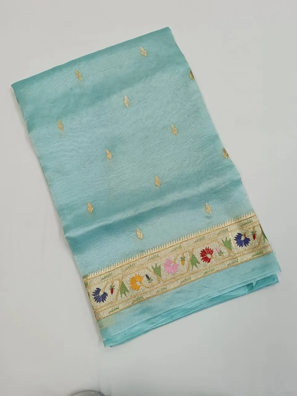 Pure Banarasi Kora Tissue saree in pastel blue with handwoven golden zari motifs and floral embroidered border, ideal for weddings.