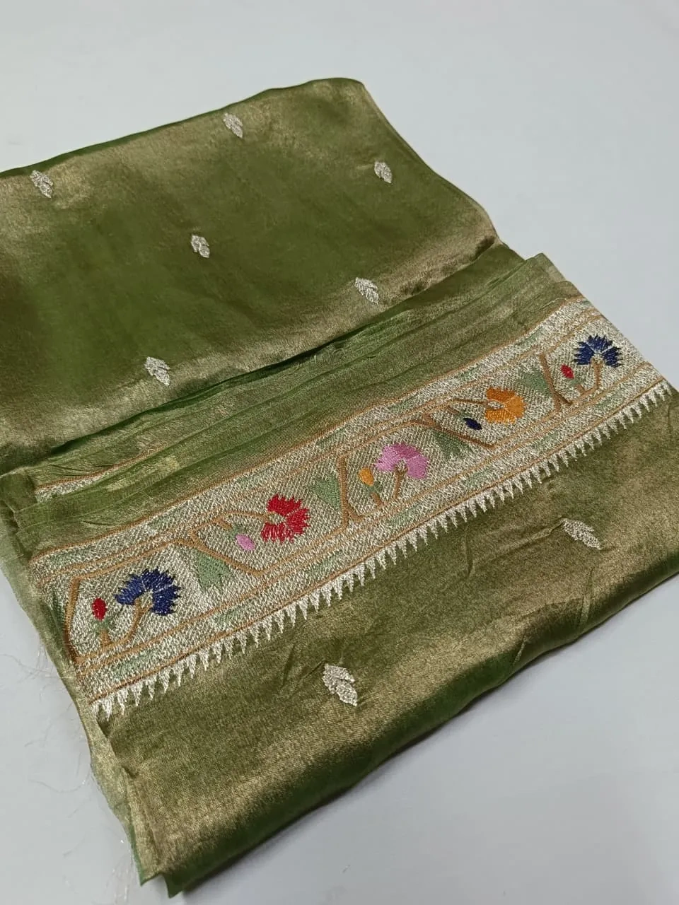 Golden Banarasi Kora tissue silk saree with intricate zari work and colorful floral border, ideal for weddings and festivals.