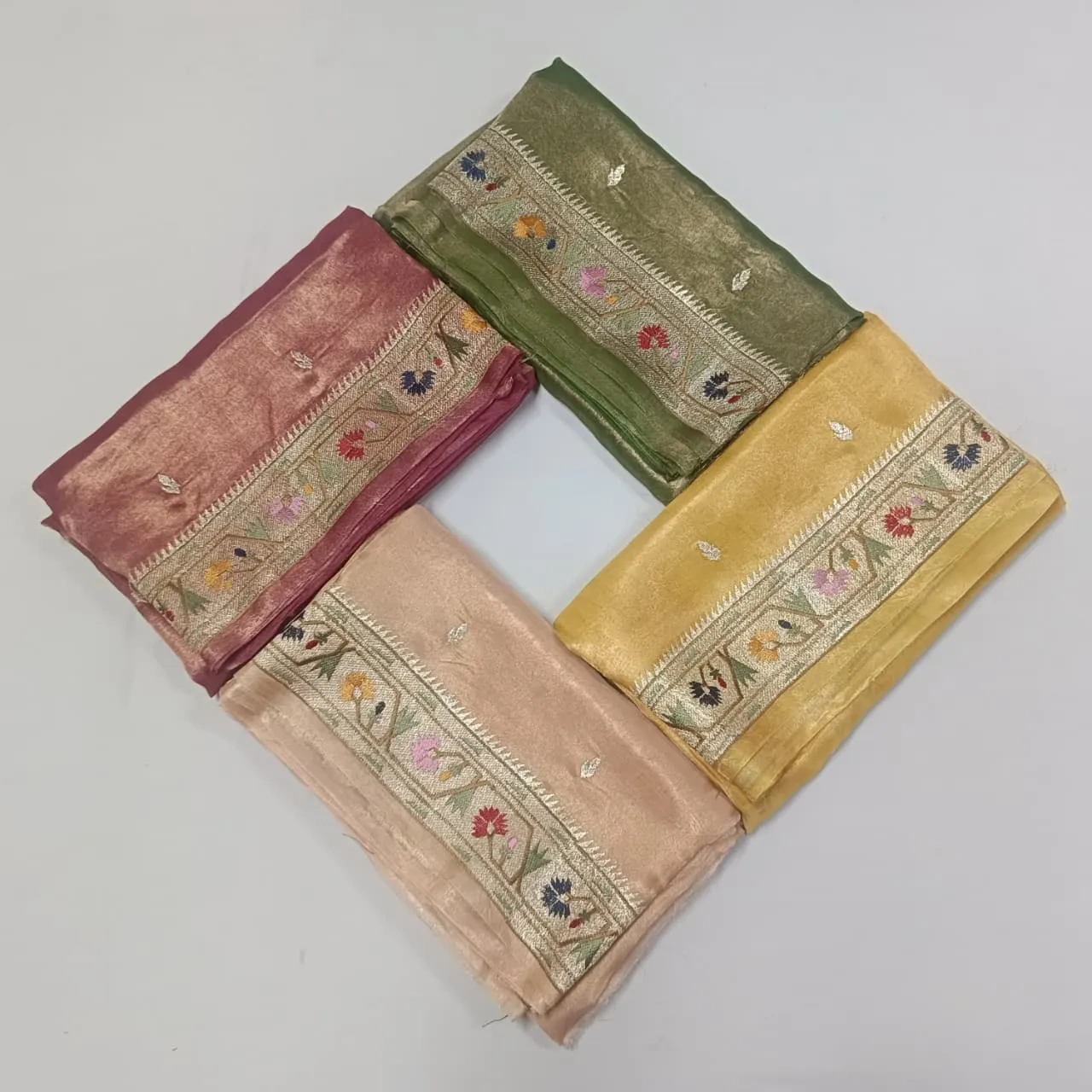 Handwoven Banarasi Kora tissue silk sarees in gold, green, pink, and beige with gold and silver zari floral borders.