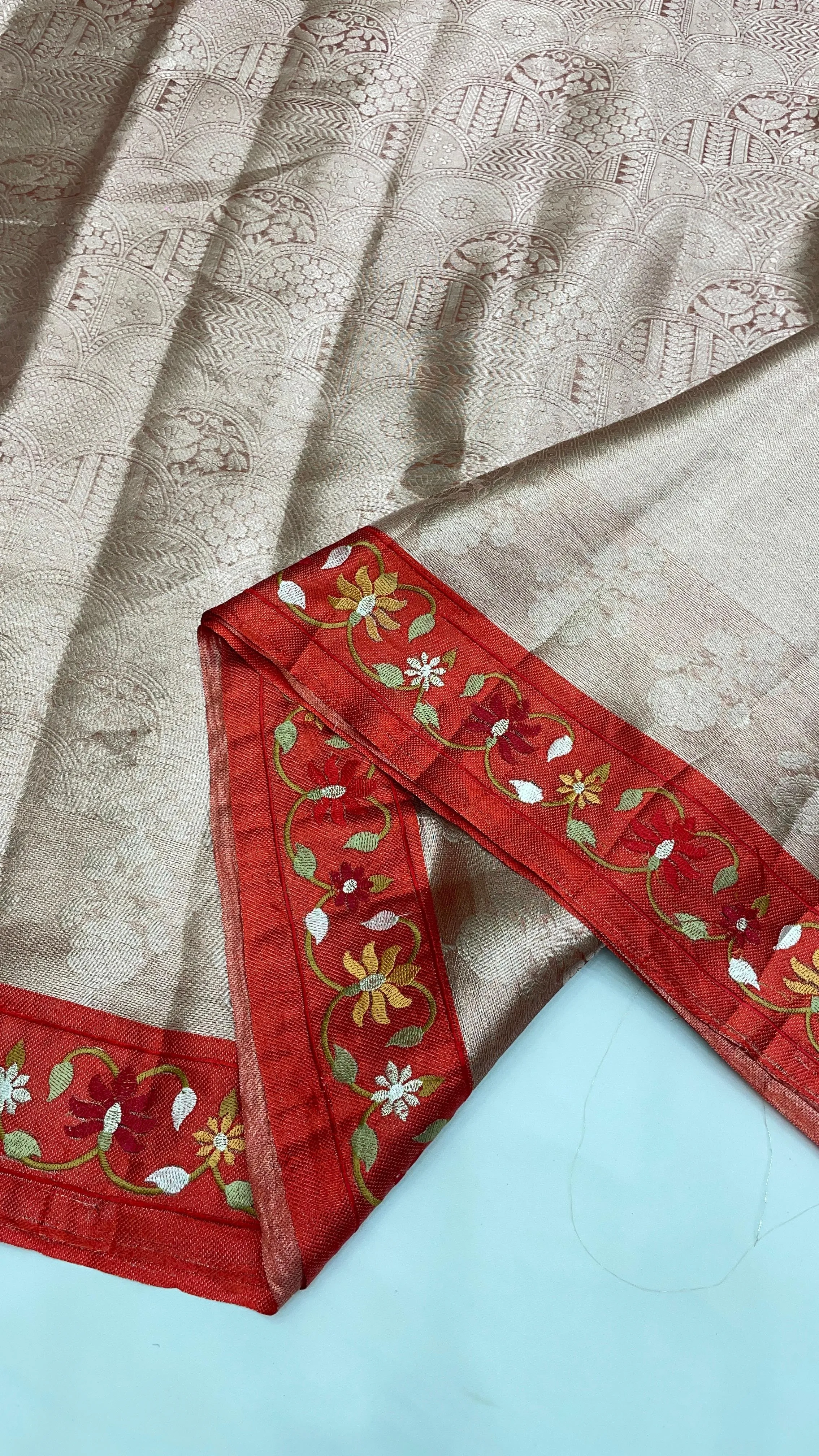Handwoven golden Banarasi tissue saree with intricate brocade work and red floral embroidered border, elegant party wear.