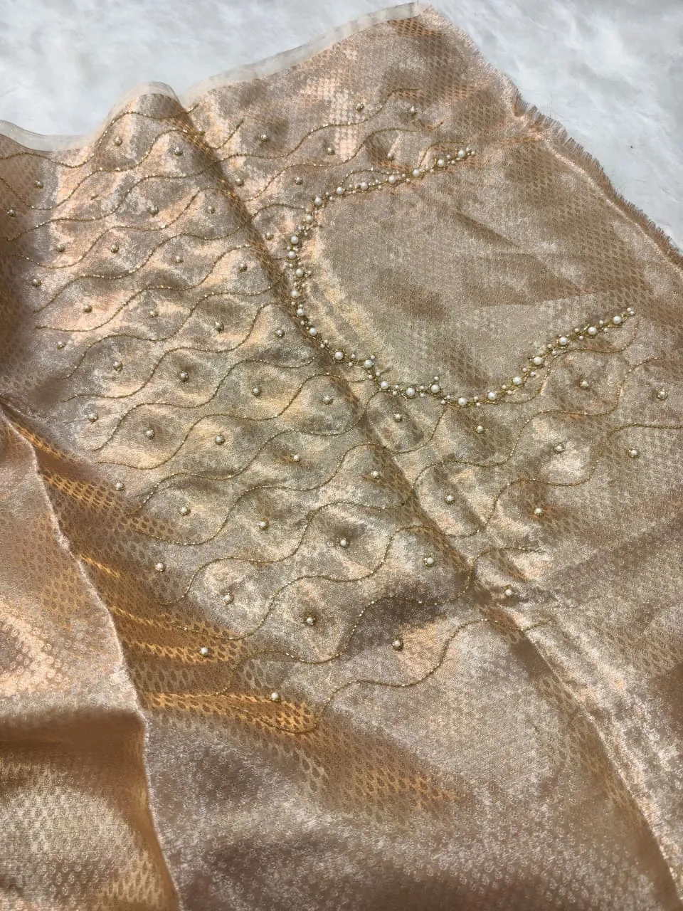 Handwoven Banarasi Kora tissue saree in gold with intricate zari work and delicate bead embellishments, perfect for weddings.