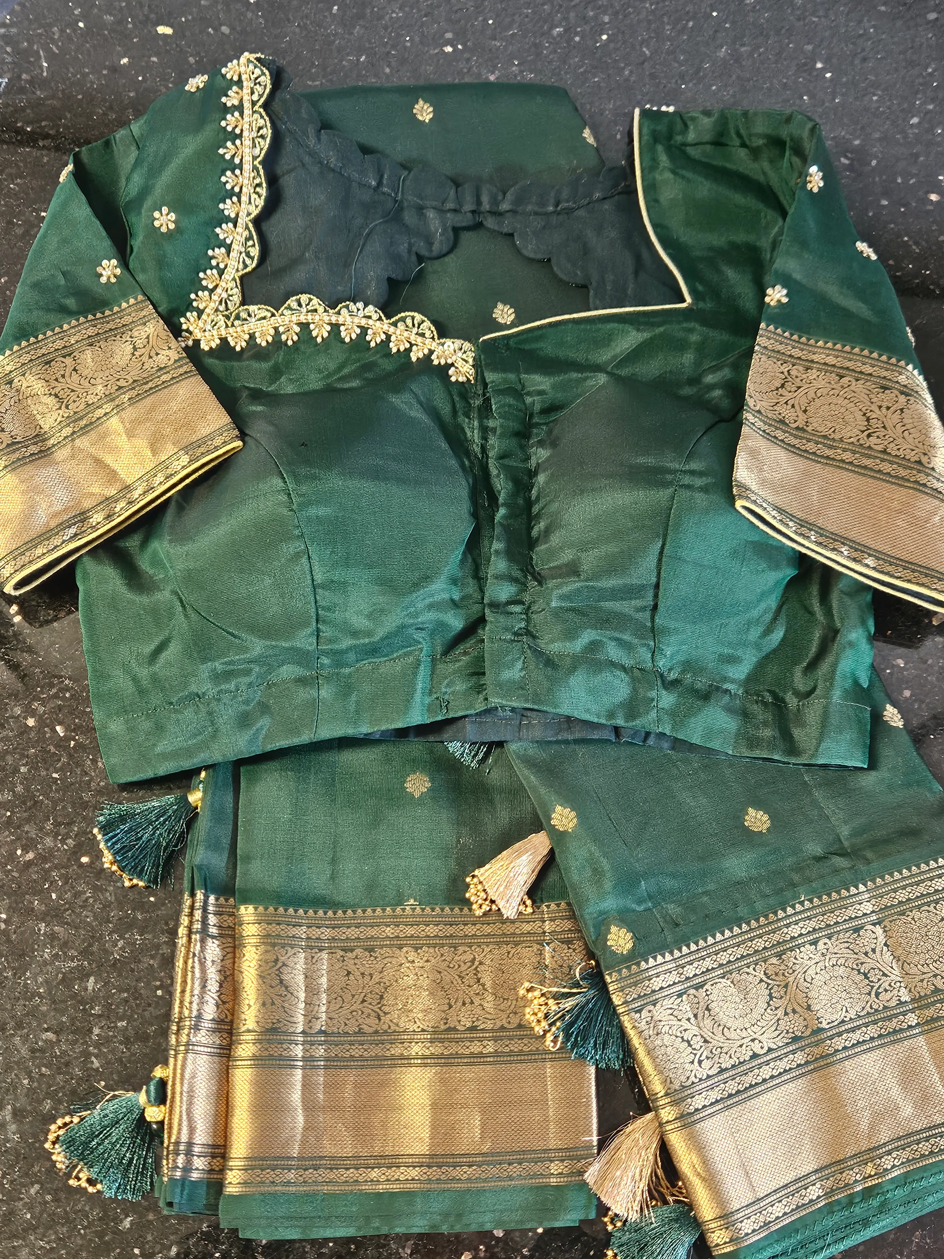 Handwoven Kanchipuram silk saree in deep green with gold zari border, matching blouse, and intricate floral detailing