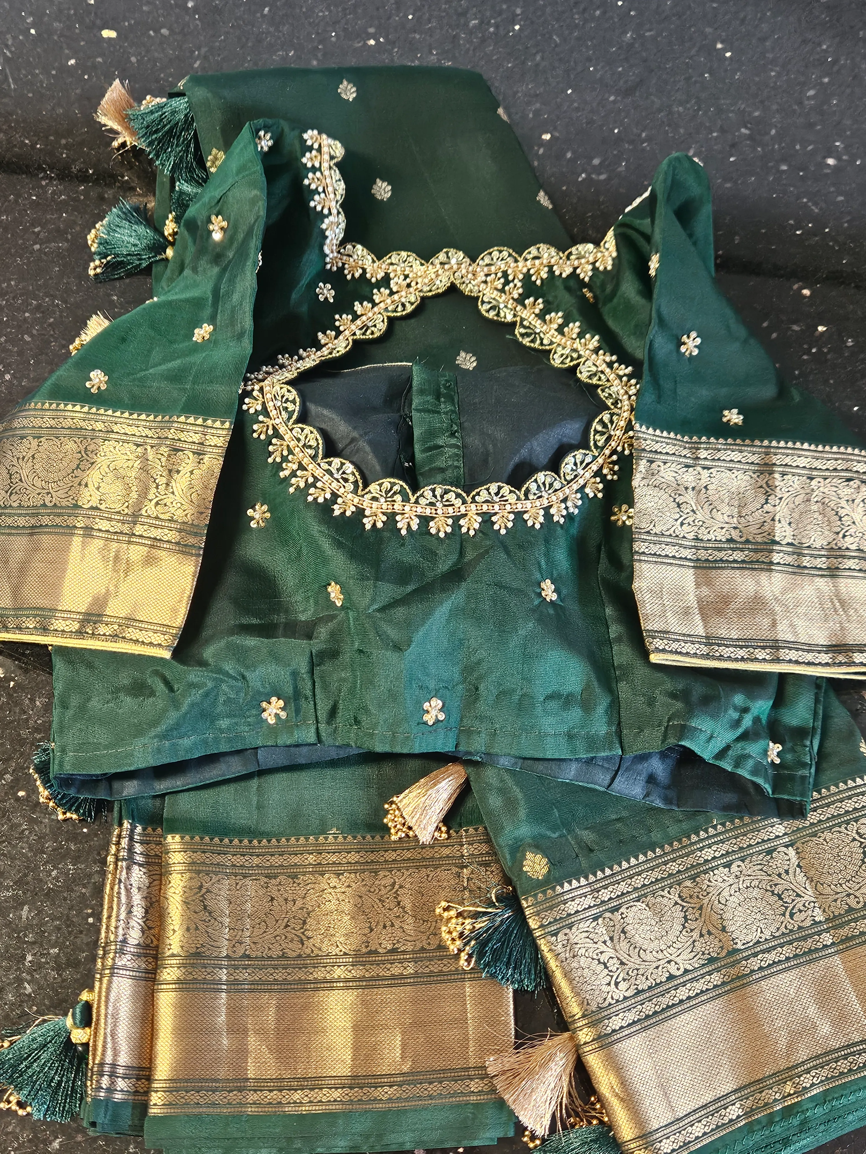 Handwoven Kanchipuram silk saree in deep green with intricate gold zari borders and small gold motifs, ideal for weddings.