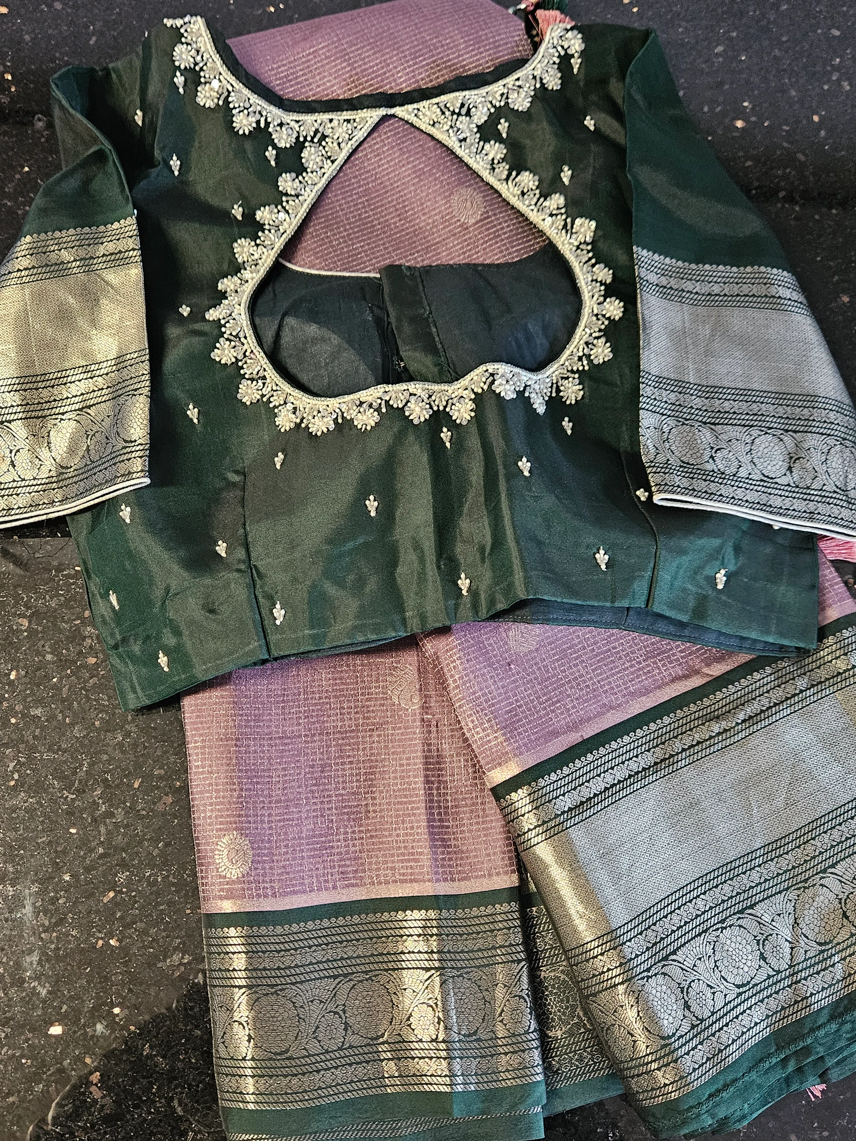 Handcrafted pure Kanchipuram silk wedding saree in lavender with silver zari motifs, paired with a green blouse featuring intricate embroidery.