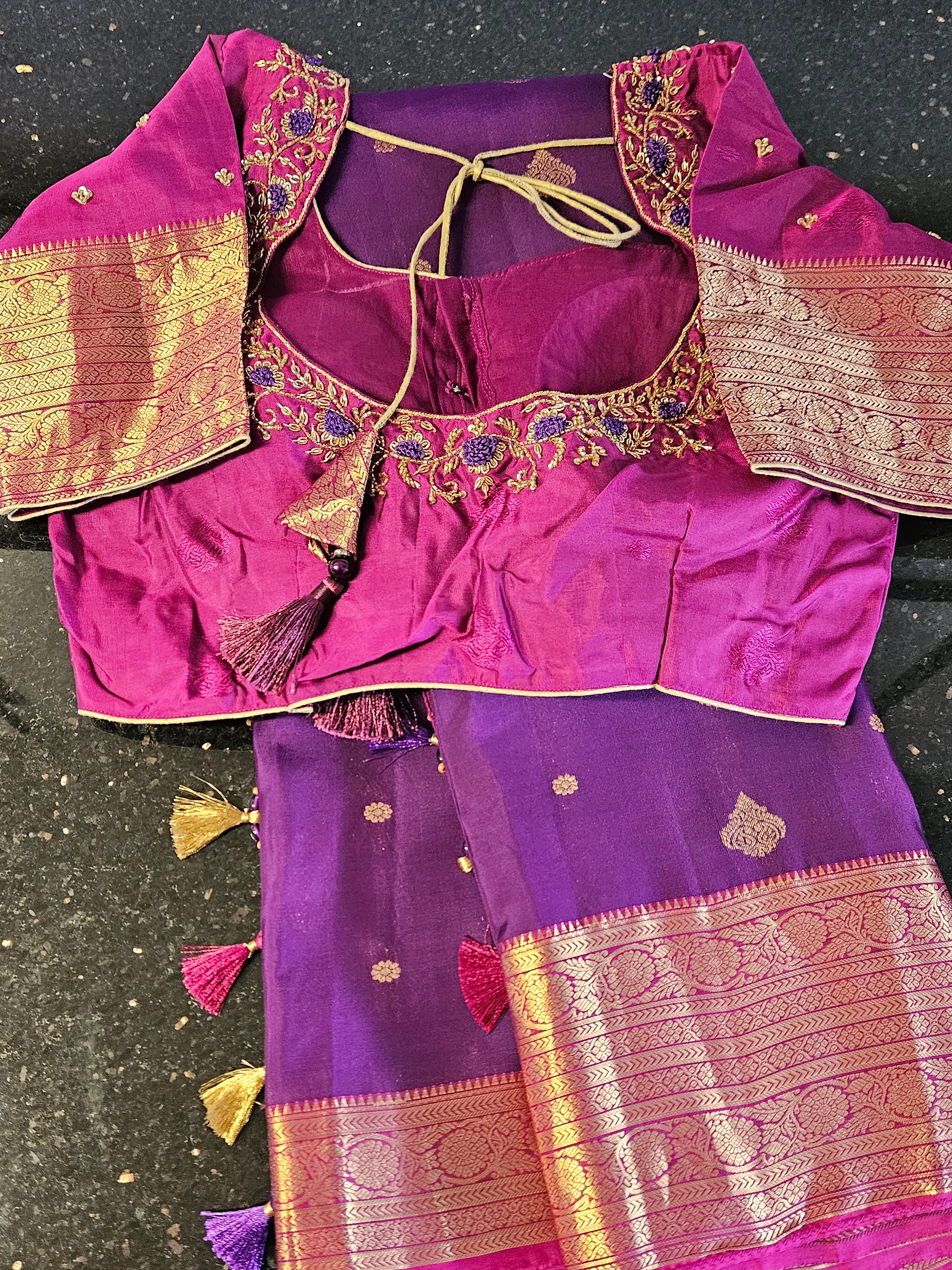 Handcrafted pure Kanchipuram silk saree in rich purple with gold zari borders and matching embroidered blouse, ideal for weddings.