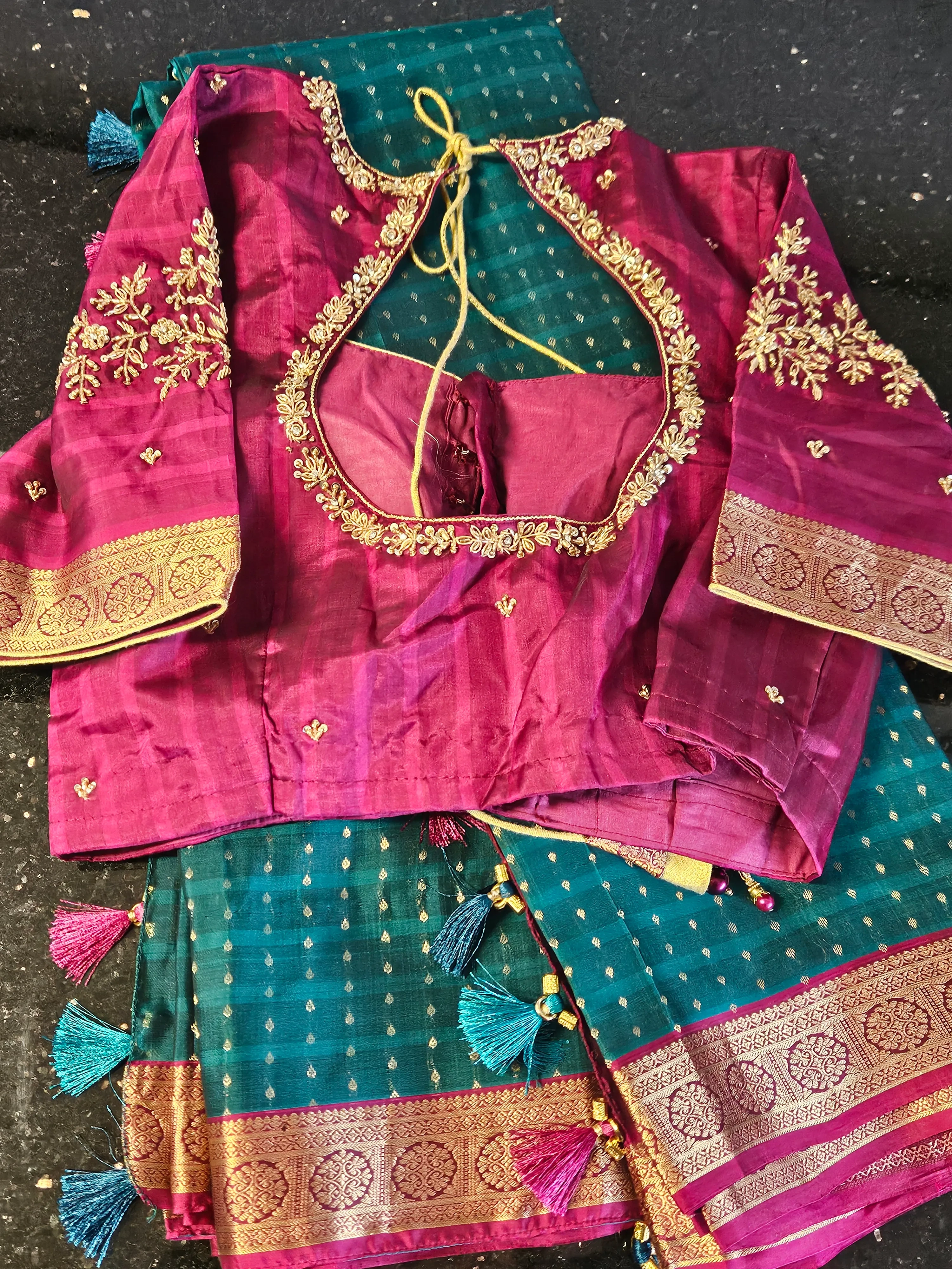Handwoven pure Kanchipuram silk wedding saree in teal with gold and silver zari work, paired with magenta blouse featuring intricate embroidery.