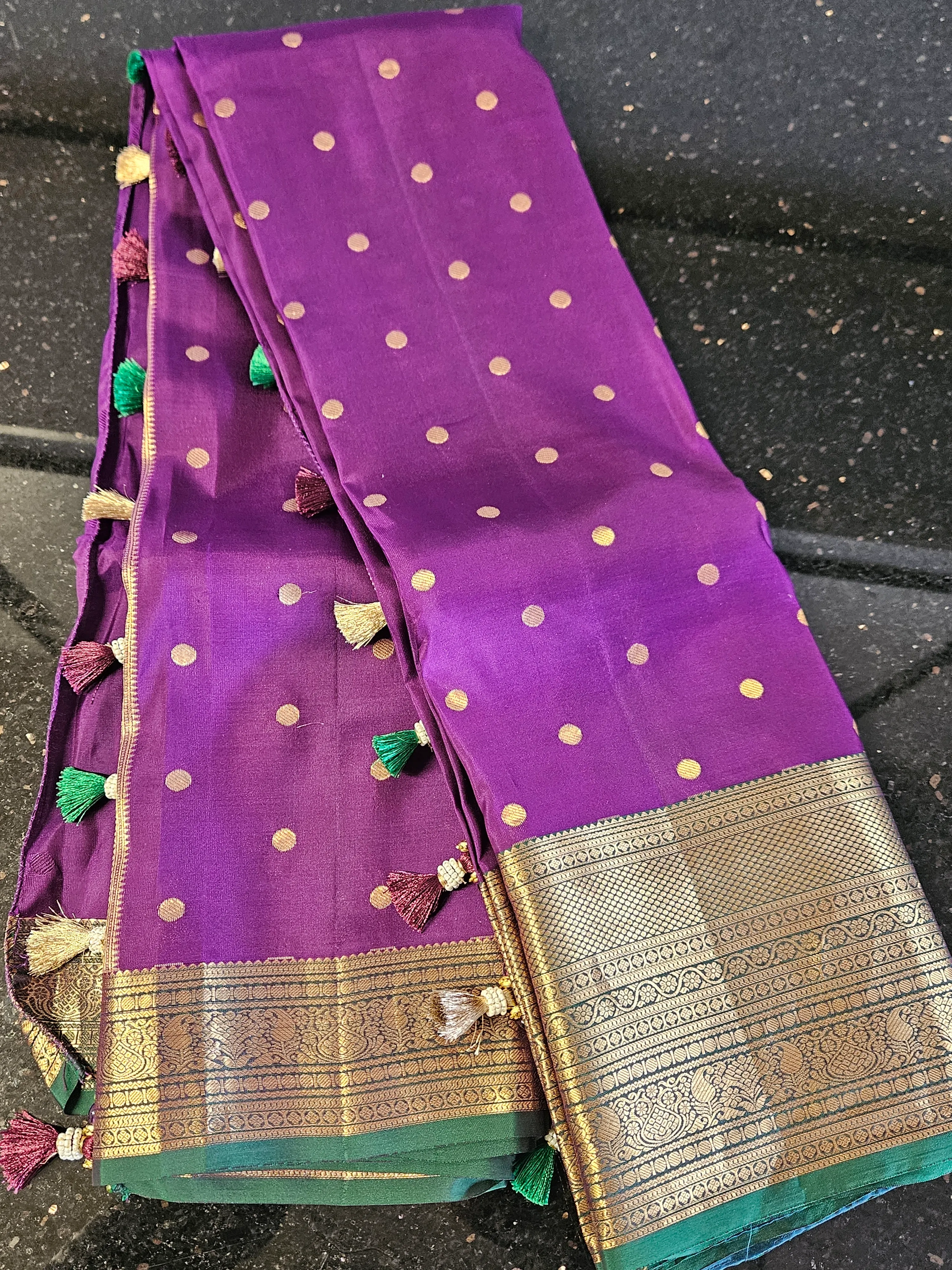 Handwoven Kanchipuram silk saree in vibrant purple with gold zari border, gold polka dots, and colorful tassels
