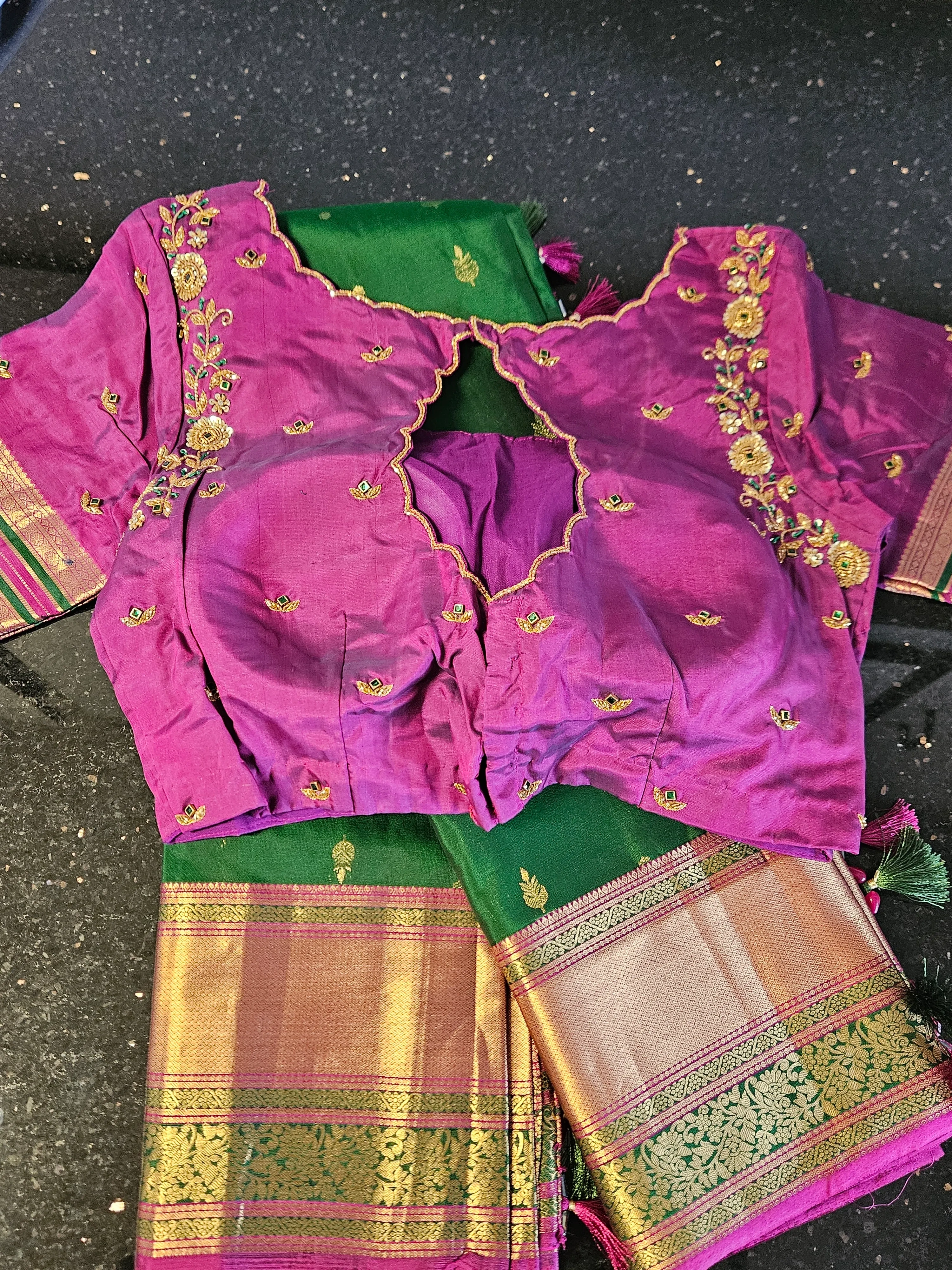 Pure Kanchipuram silk saree in emerald green with rich gold zari border, paired with a purple embroidered blouse. Perfect for bridal or festive wear.