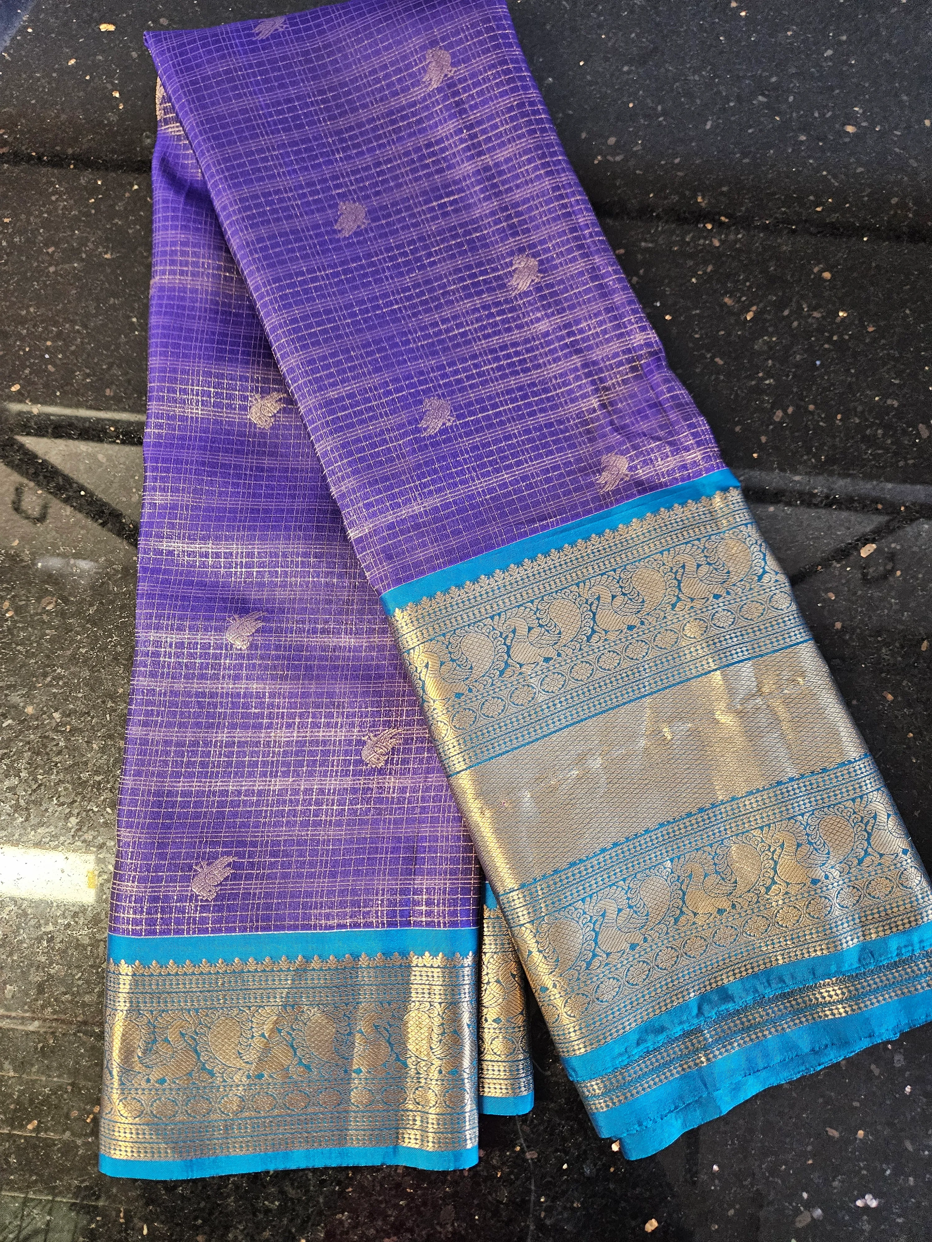 Handwoven pure Kanchipuram silk wedding saree in royal purple with gold zari work and multicolor motifs, blue border.