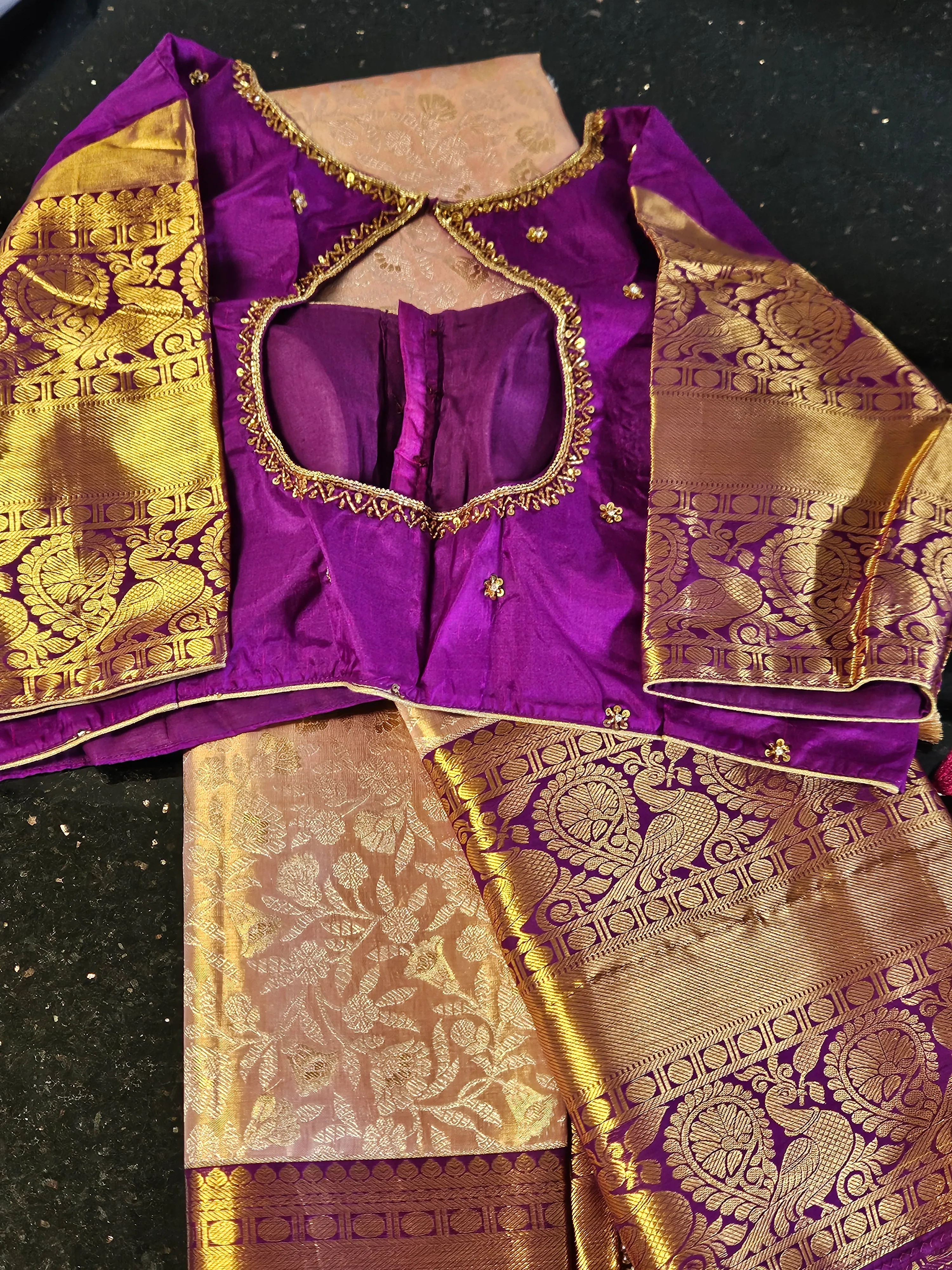 Handwoven Kanchipuram silk saree in rich purple and gold with intricate zari work, paired with a matching blouse.