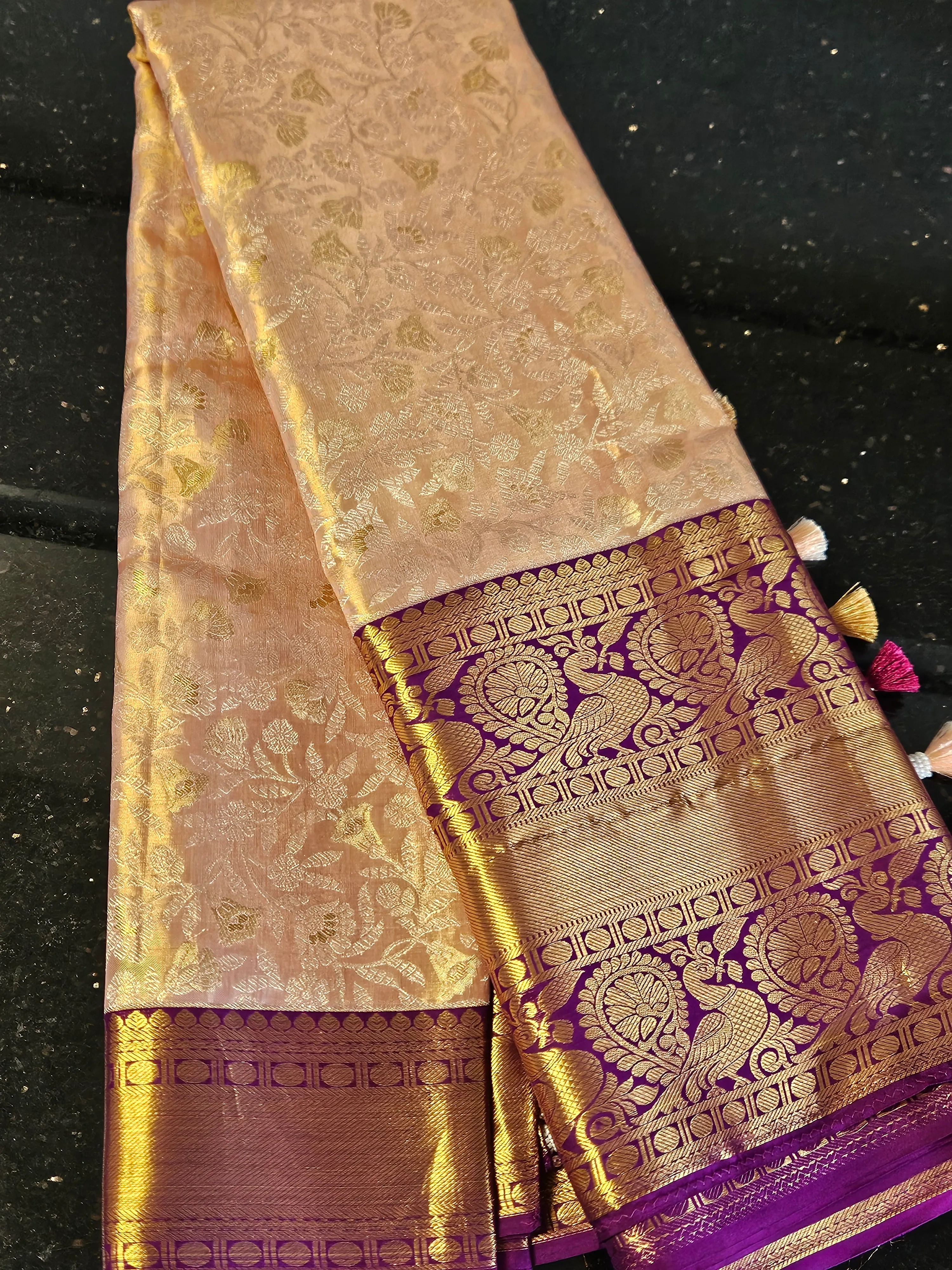 Handwoven Kanchipuram silk saree in soft gold with intricate gold zari motifs and rich purple zari border, ideal for weddings.