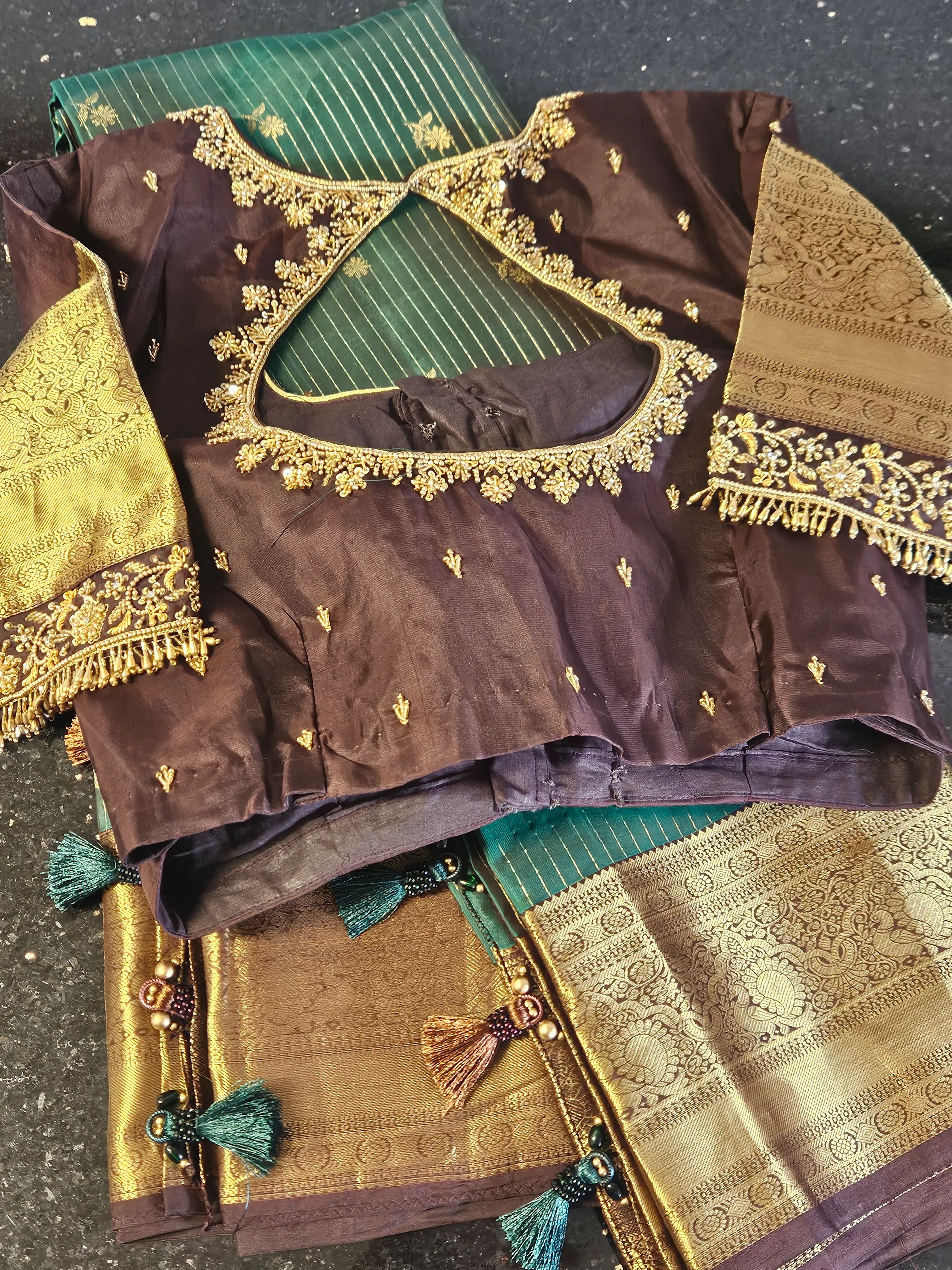 Pure Kanchipuram silk wedding saree in green with gold zari work, paired with a purple blouse featuring gold embroidery.