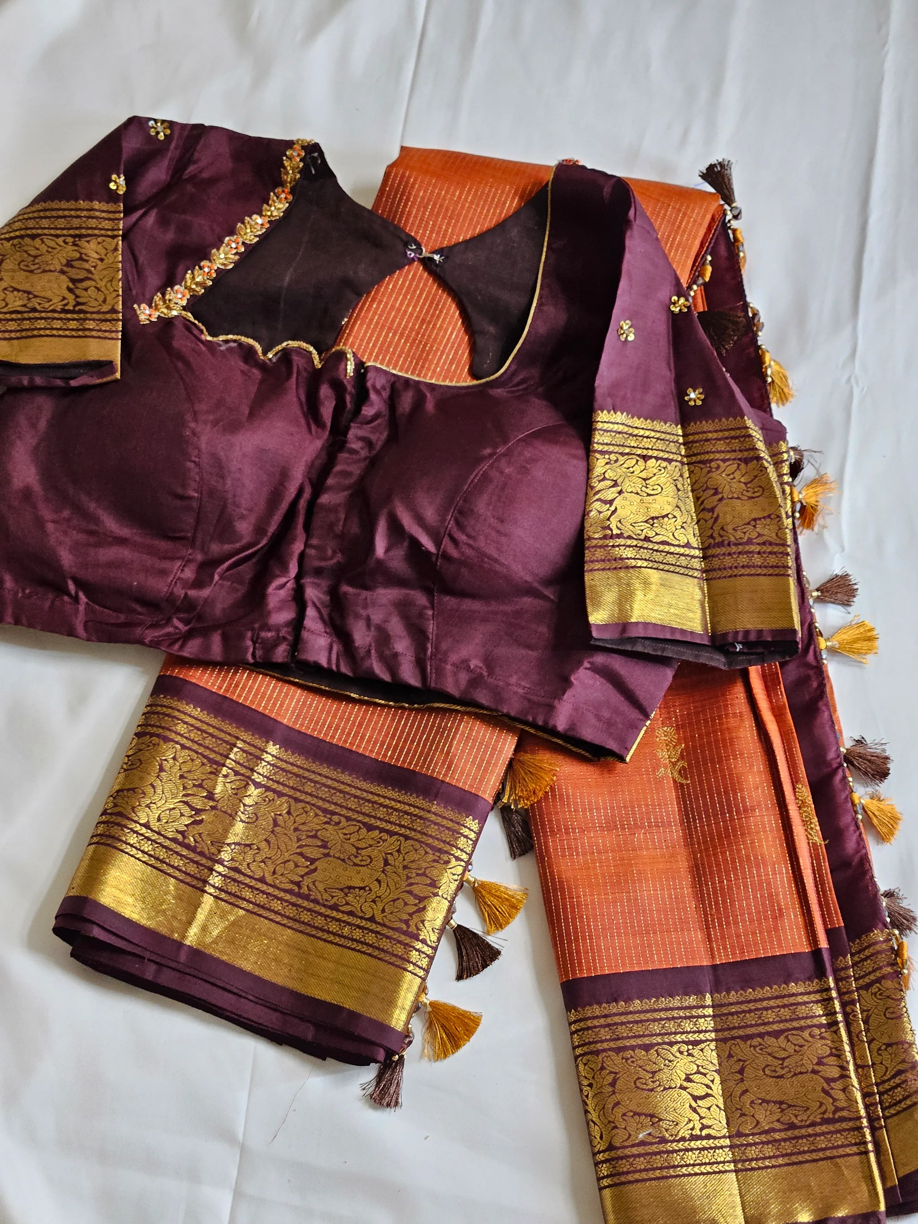 Handwoven pure Kanchipuram silk saree in golden yellow with rich maroon blouse, featuring intricate gold zari work and tassel details.