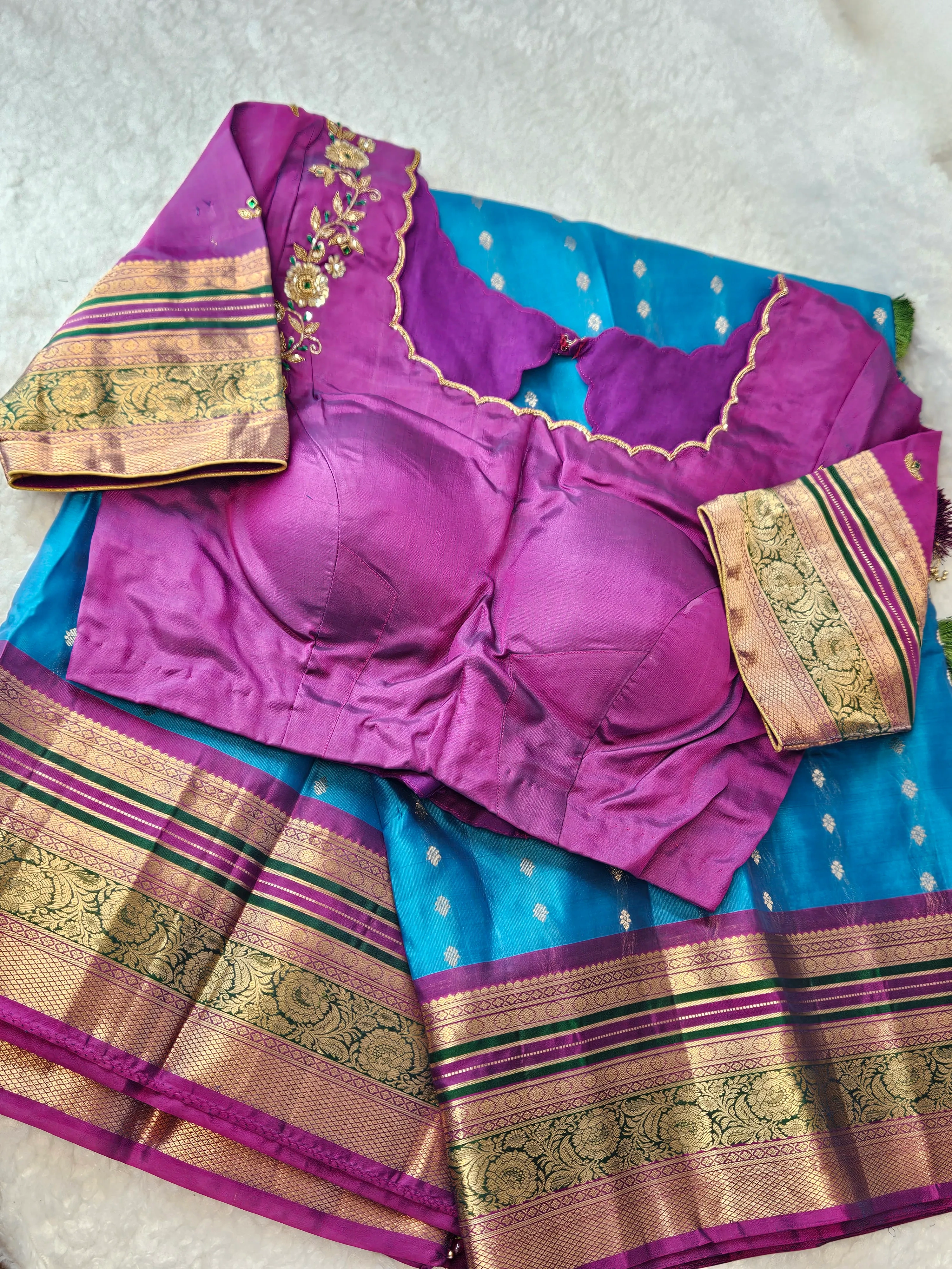 Handwoven Kanchipuram pure silk saree in vibrant blue with gold zari border, paired with a purple blouse featuring gold embroidery