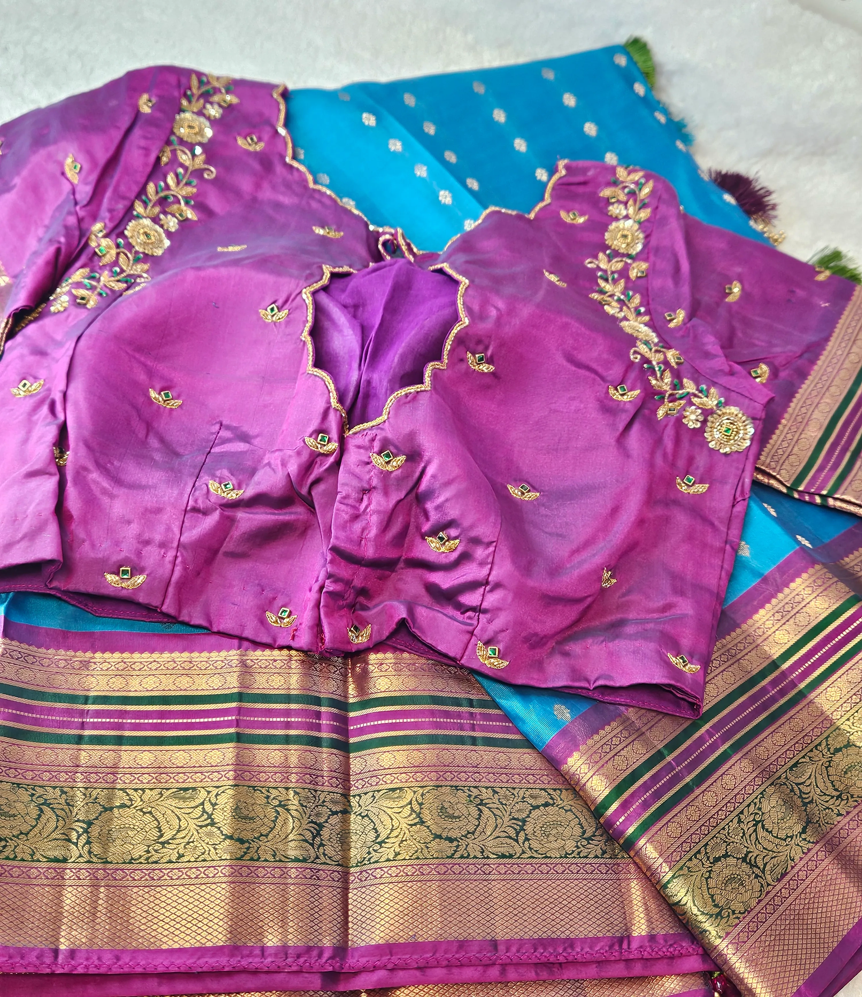 Handwoven Kanchipuram pure silk saree in blue with gold zari borders, paired with a purple embroidered blouse, ideal for bridal wear.